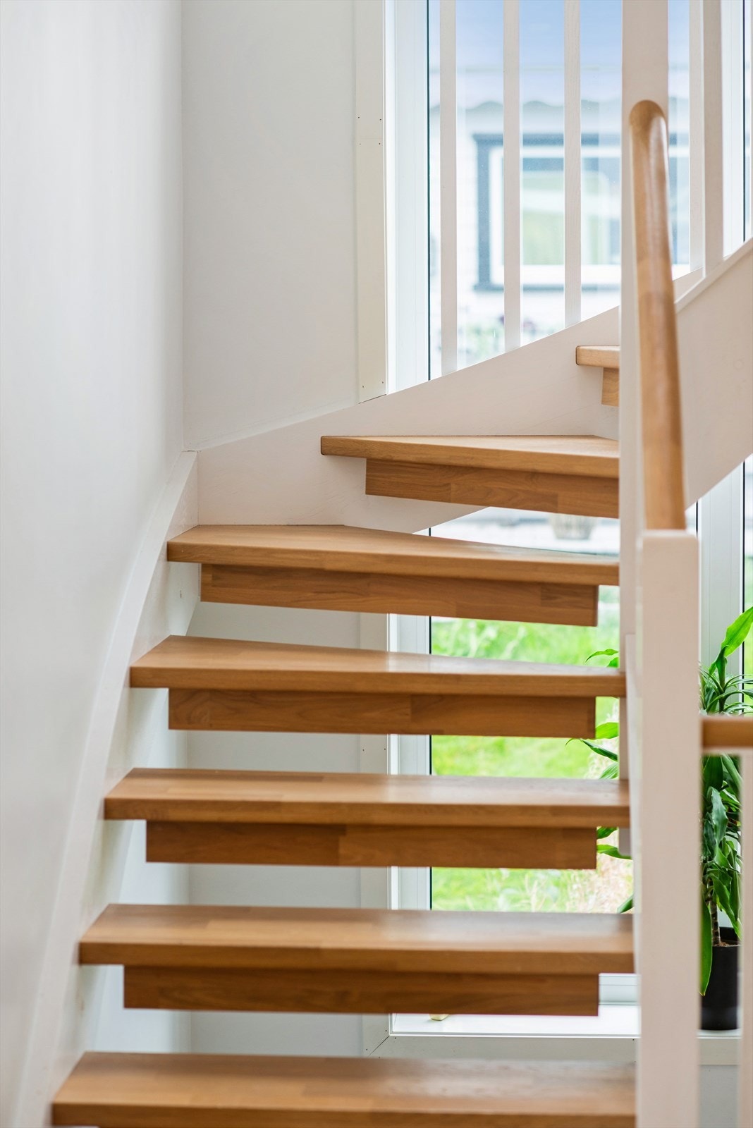 Solid tretrapp med rekkverk i treverk som forbinder boligens etasjer. Galleribilde