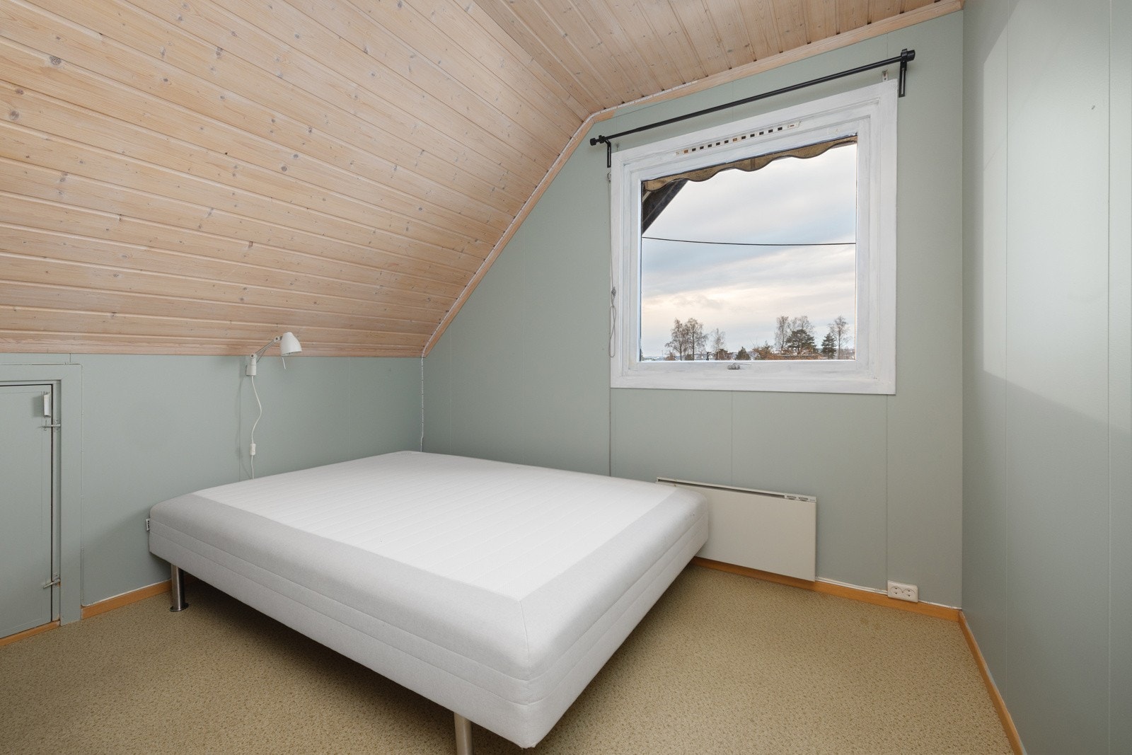 Lyst soverom i loftsetasje med vindu og skråtak. Galleribilde