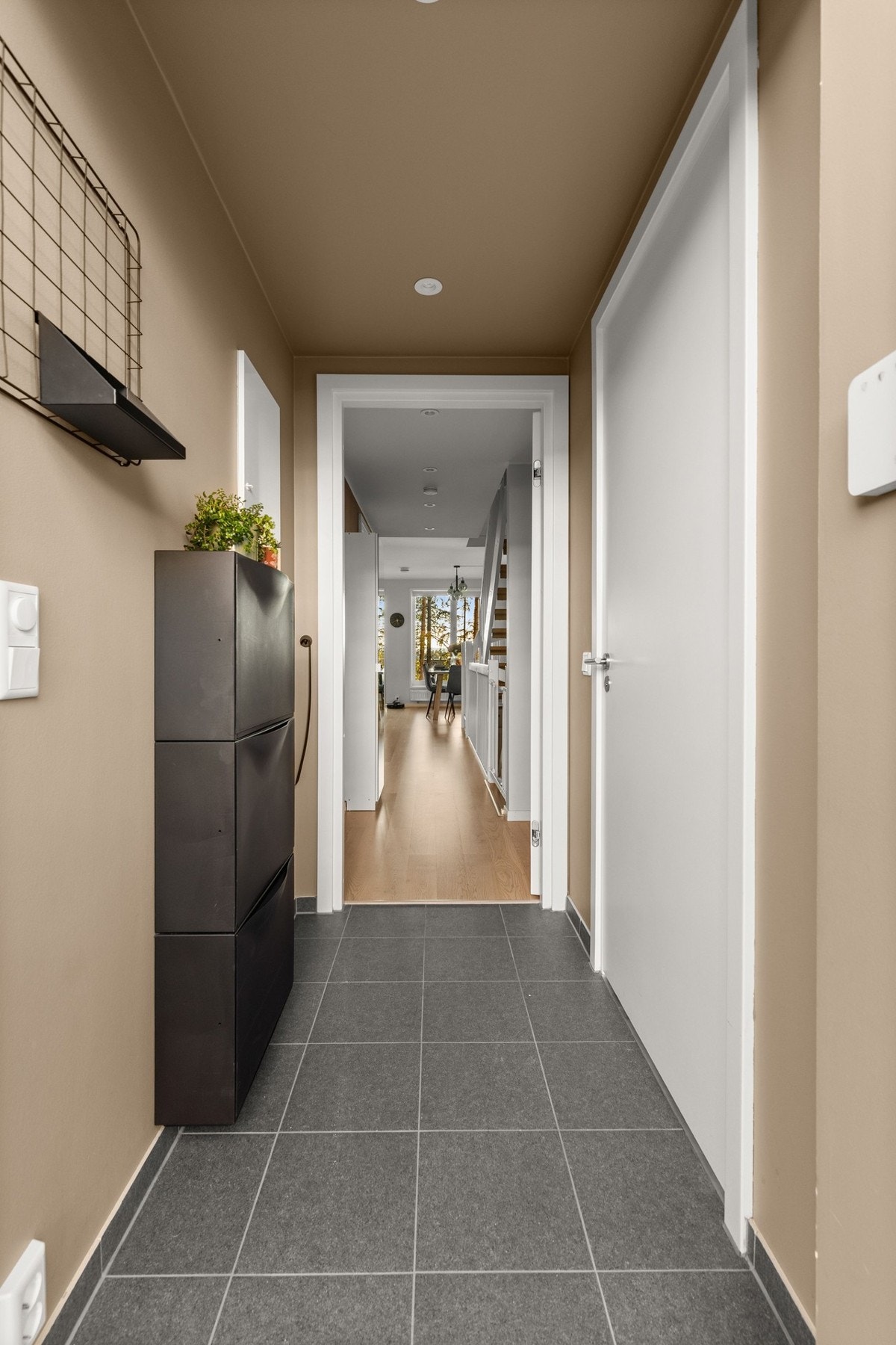 Boligen ønskes velkommen gjennom en praktisk og innbydende entré med flislagt gulv, som gir en slitesterk og funksjonell løsning i hverdagen. Galleribilde