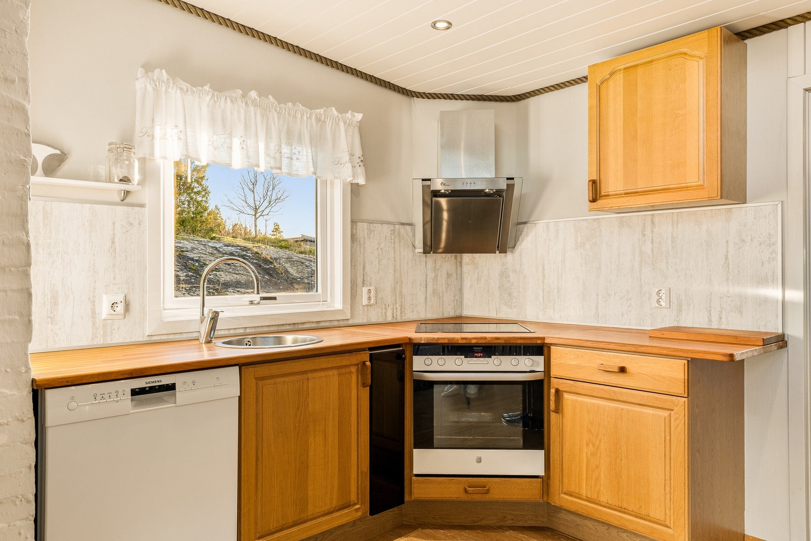 Kjøkkenet er utstyrt med oppvaskmaskin, stekeovn og koketopp. Galleribilde