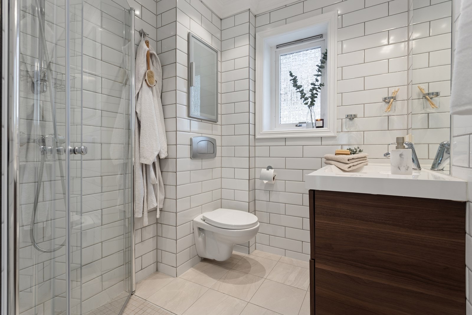 Lyst, helfliset baderom som ble pusset opp i 2005/2006. i 2017 ble det lagt nytt flisegulv utenfor dusjsonen. Galleribilde