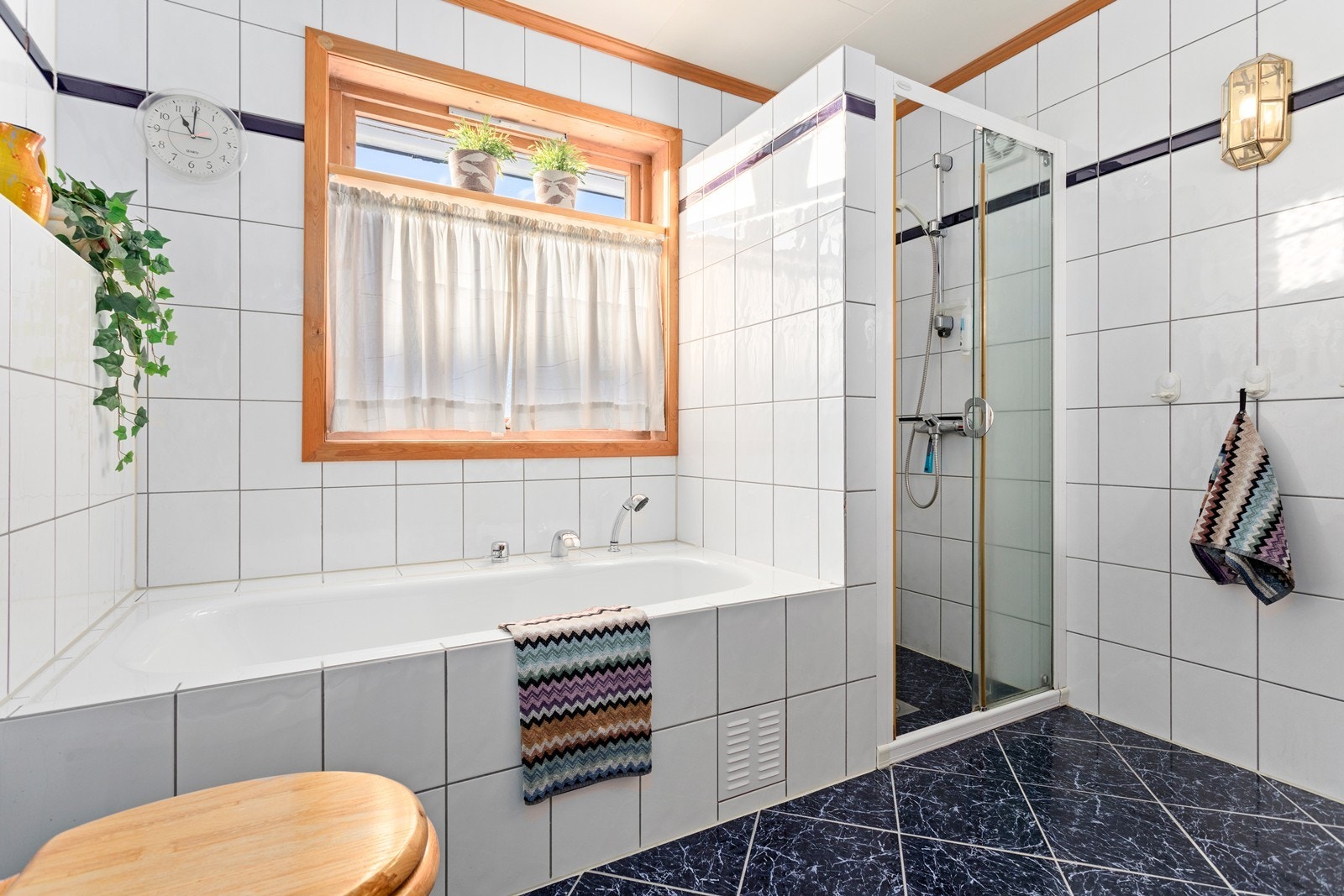 Heilflisa bad med varmekablar i golv utstyrt med både dusj og badekar. Galleribilde