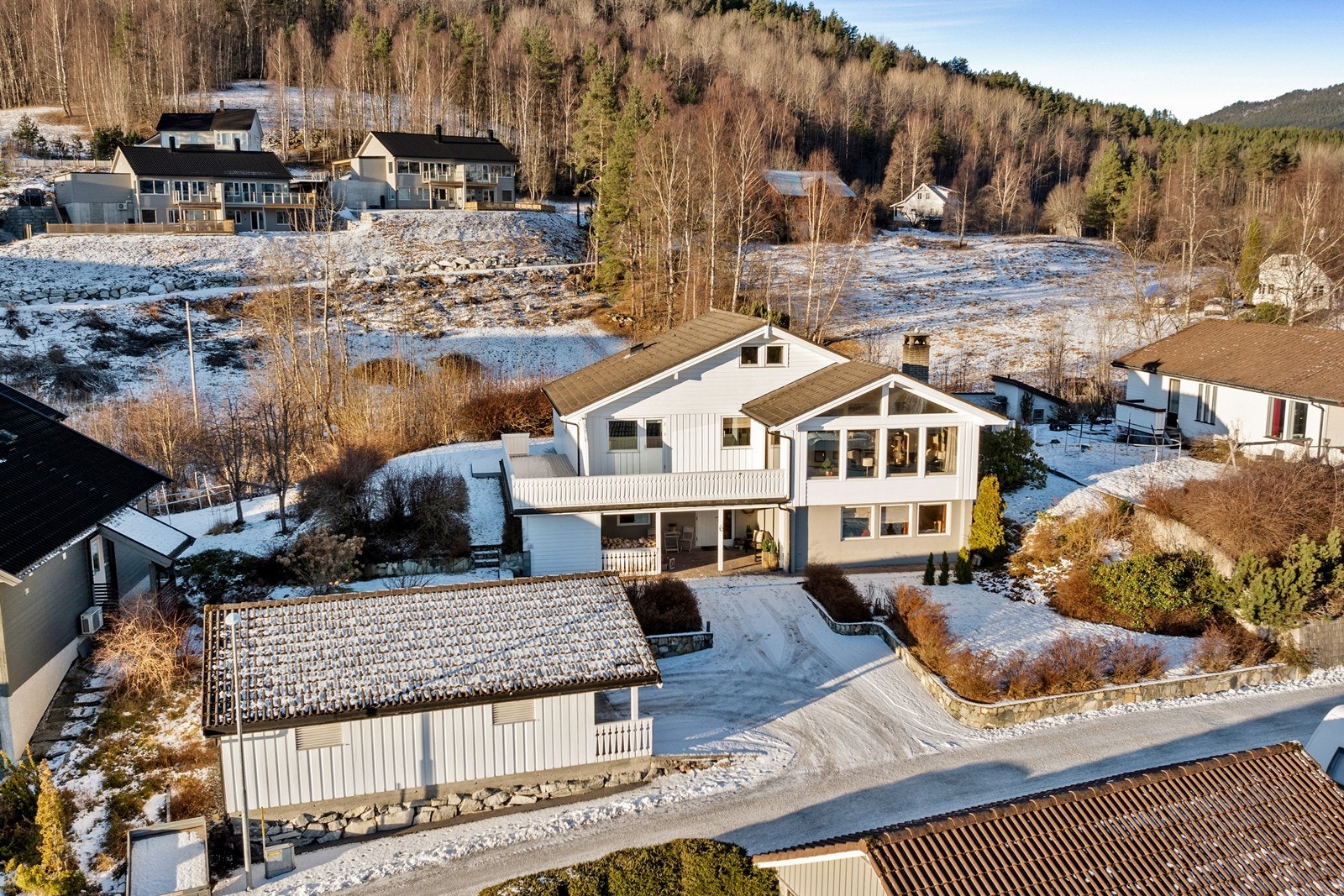 Tomta er pent opparbeida med asfaltert tun, murar, plenareal og variert beplantning. Galleribilde