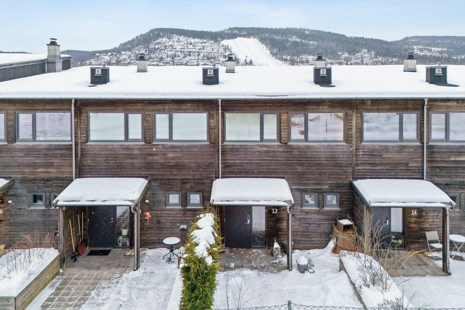 Inngangspartiet ligger nord-øst vendt og er pent opparbeidet med heller. Her har man god plass til å møblere med både sittegruppe og krukker. Et trivelig område hvor man kan nyte morgensola. Galleribilde