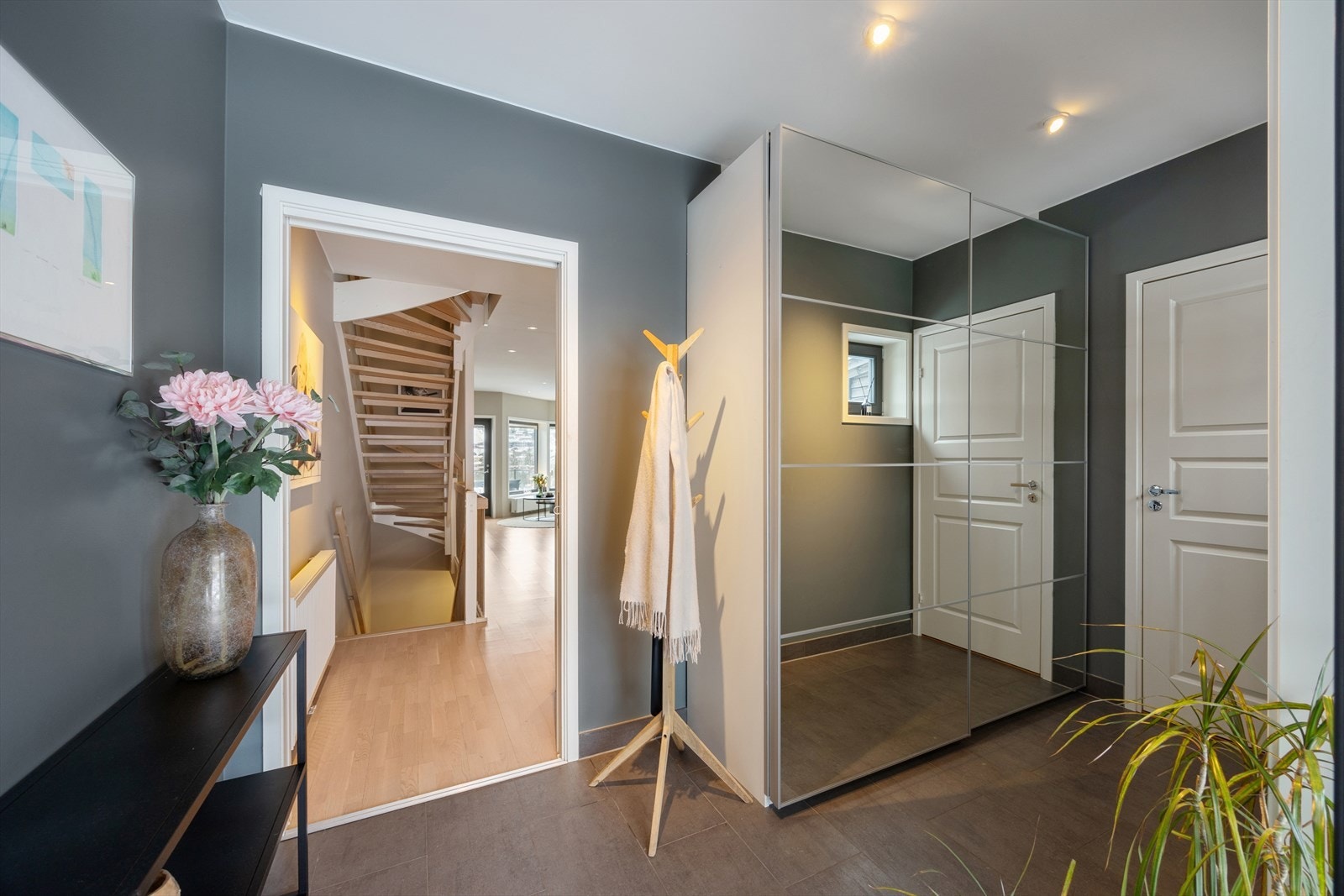 Hovedentreen ligger i første etasje og gir umiddelbart et godt førsteinntrykk av boligen. Romslig og praktisk innredet med flislagt gulv og skyvedørsgarderobe med god lagringsplass. Galleribilde