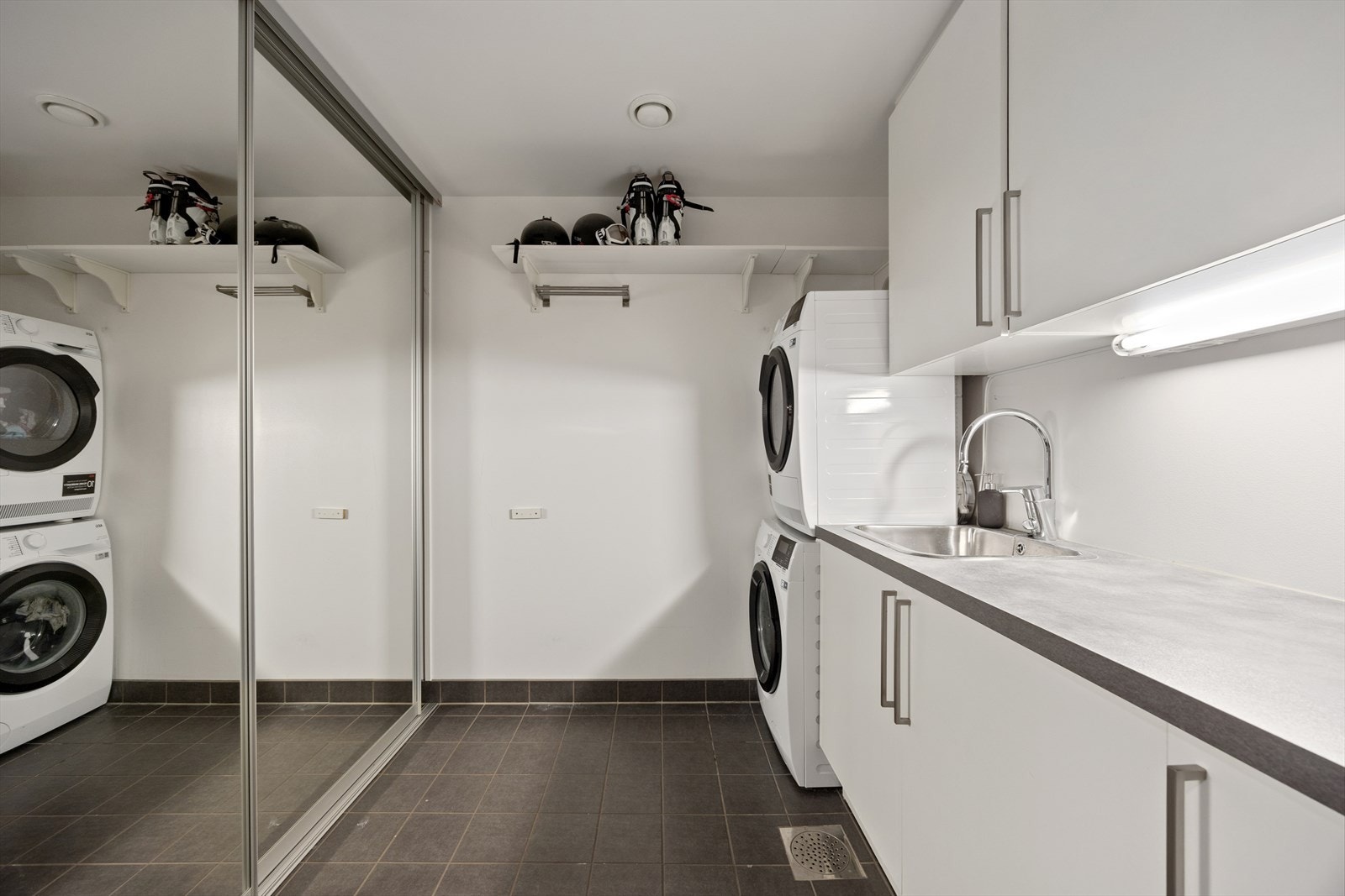 Stort og meget praktisk vaskerom med varmekabler. Rommet er ellers utstyrt med opplegg for vaskemaskin, vask og innredning som gir god lagringsplass. Galleribilde