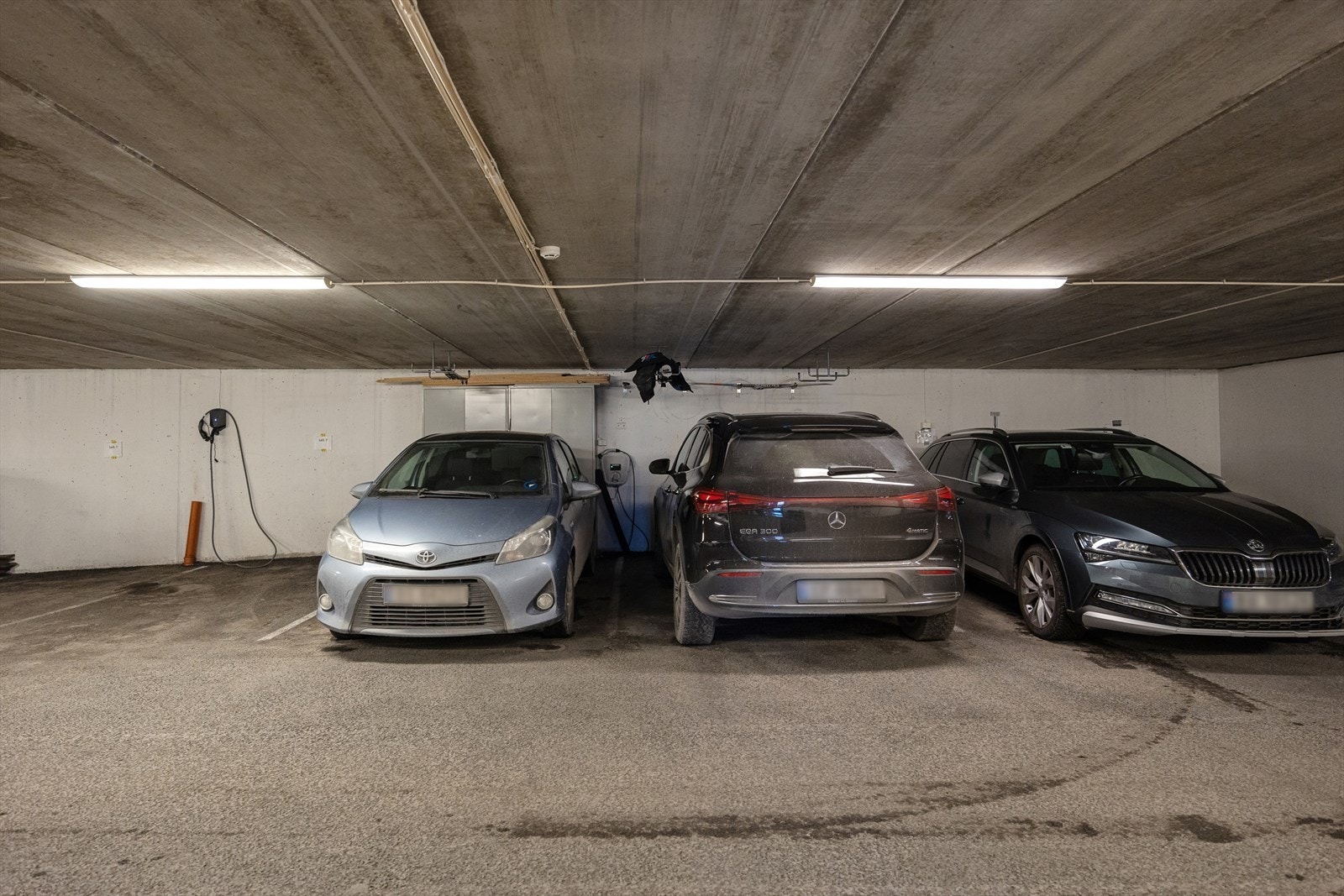 Boligen disponerer to parkeringsplasser med én elbillader i lukket anlegg. På parkeringsplassen har man også skap som gir ekstra lagring. Galleribilde