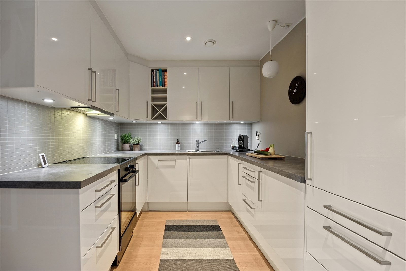 Kjøkkenet er levert av kvalitetsleverandøren Sigdal. Et stilrent og flott kjøkken innredet med hvite, glatte fronter og grå benkeplate i laminat. Her får man godt med skap- og skuffeplass, samt gode arbeidsflater på benk. Galleribilde