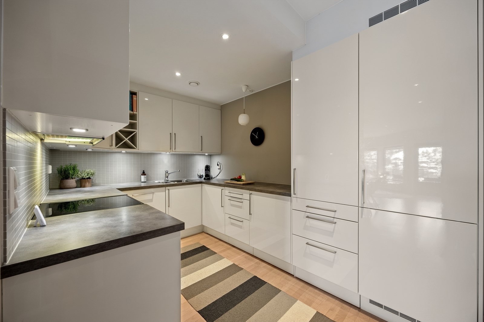 Kjøkkenet er ellers utstyrt med kombiskap, oppvaskmaskin, stekeovn, koketopp, vannstoppsystem og kjøkkenventilator med avtrekk via balansert ventilasjonsanlegg. Galleribilde