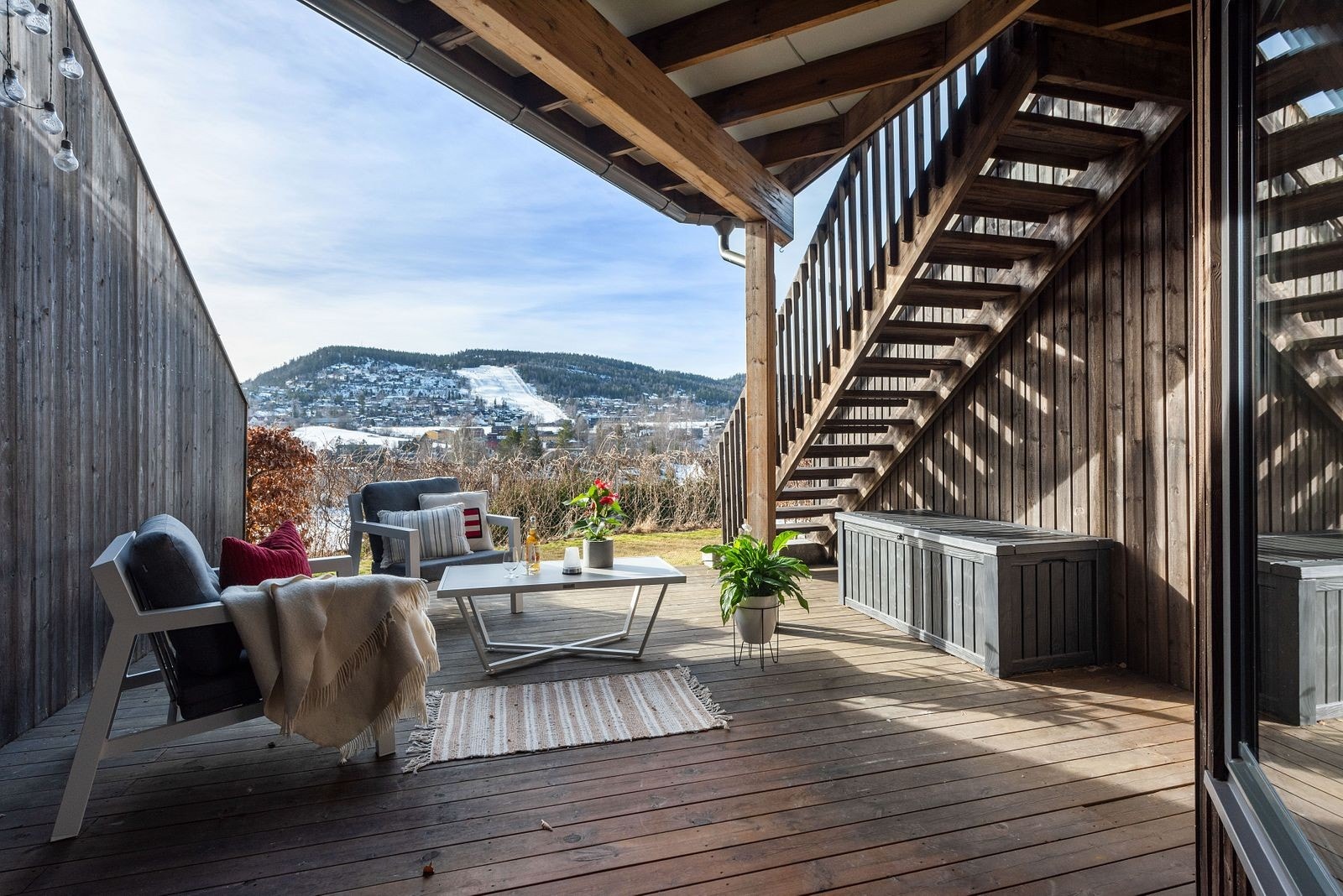 En skjermet, solrik og innbydende uteplass med både terrasse og gressplen. Galleribilde