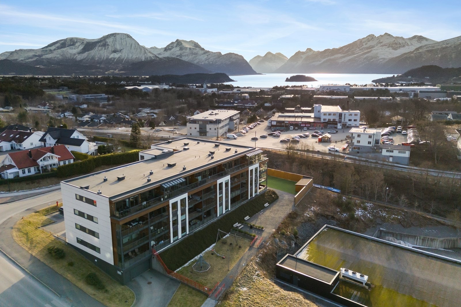 Tomten er pent opparbeidet med lekeplass, plen og beplantning. Galleribilde