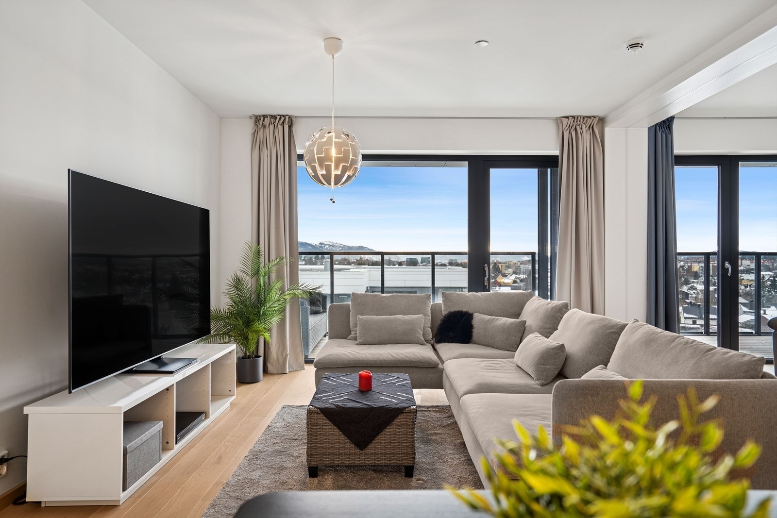 Stue med store vindusflater som slipper inn rikelig med naturlig lys og gir rommet en lun og innbydende atmosfære gjennom hele dagen. Galleribilde