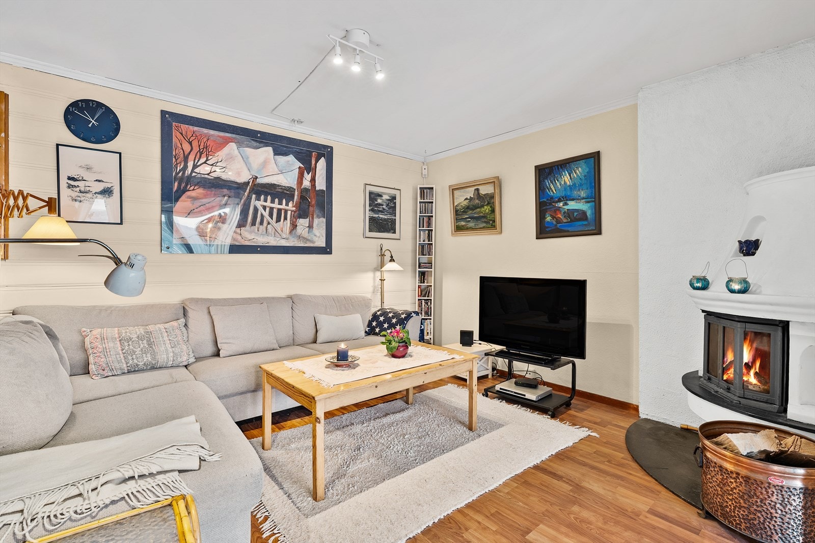 Rommet har lyse overflater, parkettgulv og peis med innsats. Galleribilde