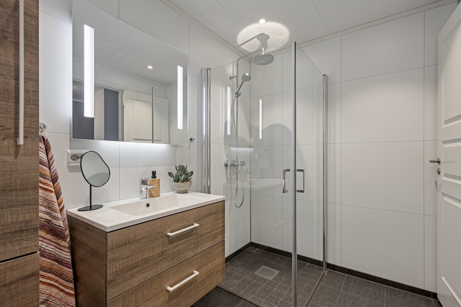 Badet ble pusset opp i 2022 og er tidløst innredet med grå fliser på gulvet og hvite baderomsplater på vegg. Varmekabler i gulv. Galleribilde