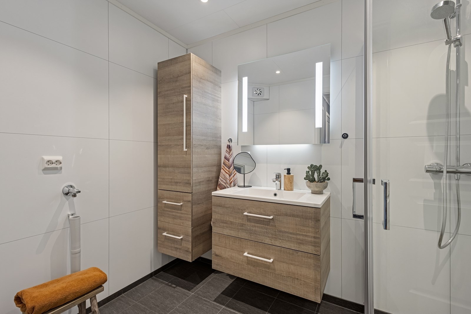 Badet er ellers utstyrt med dusjhjørne, baderomsinnredning med god lagringsplass og nedfelt servant og opplegg for vaskemaskin. Galleribilde