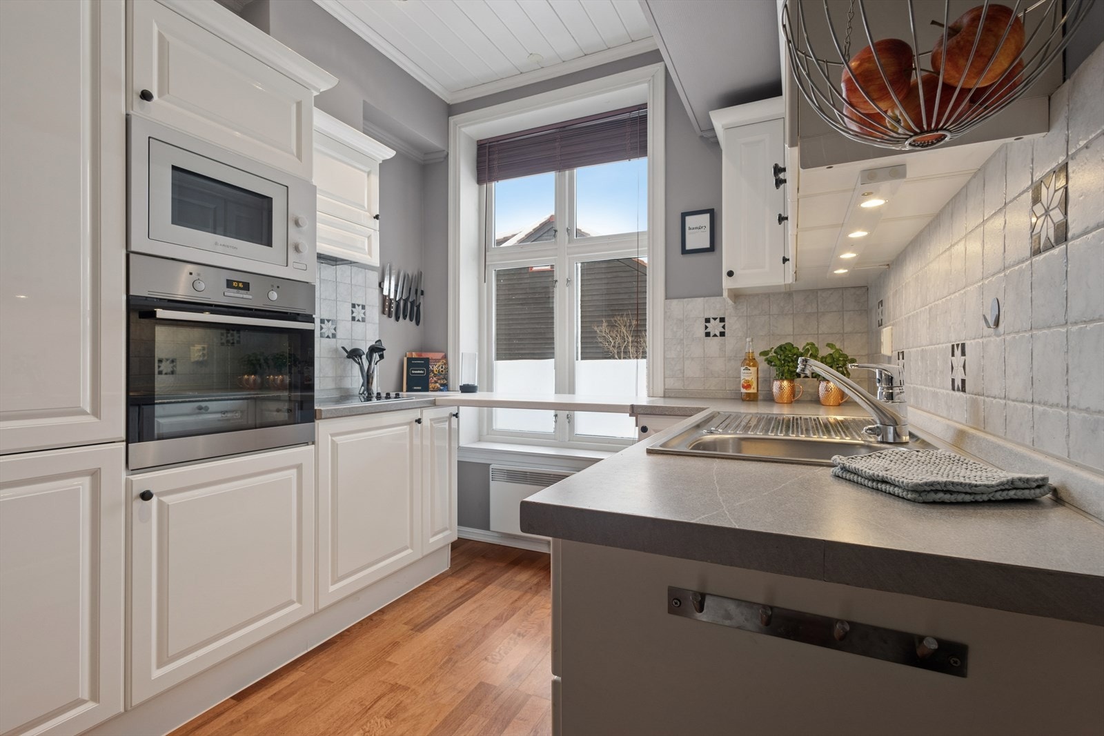 Kjøkkenet har en pen innredning fra 2007 med profilerte, hvite fronter og laminatbenkeplate med nedfelt kjøkkenkum. Galleribilde