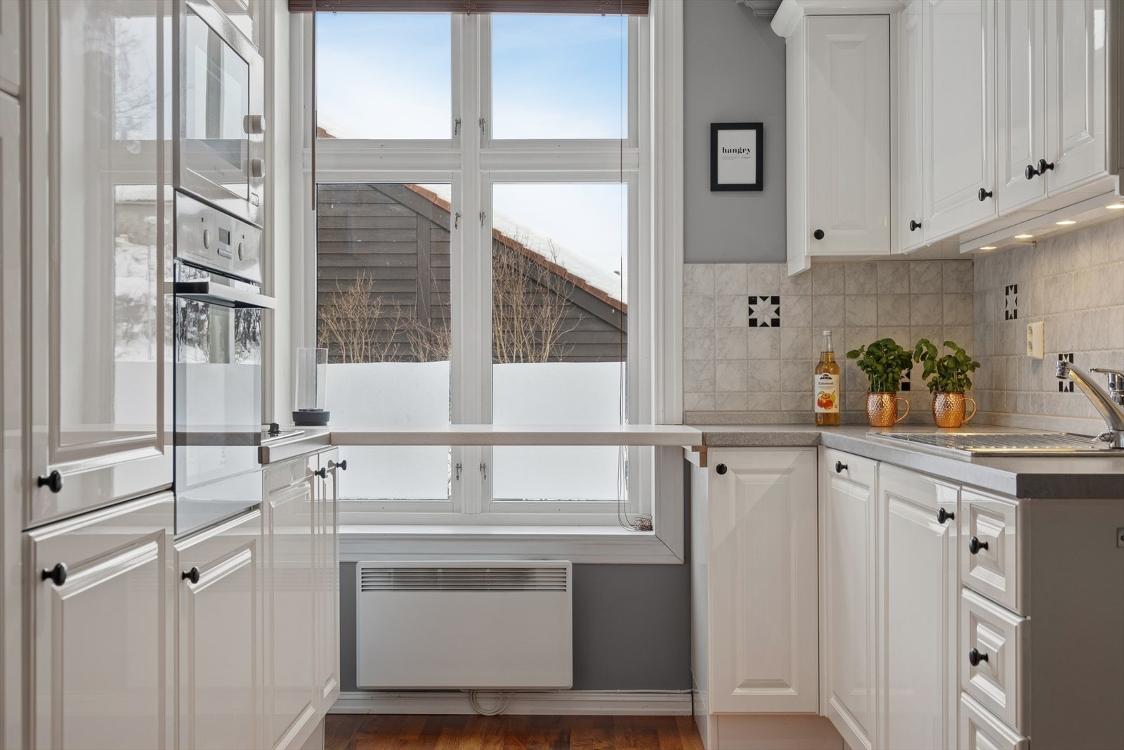 Det er montert belysning over benkeplaten som gir gode arbeidsforhold, og benkeryggen har dekorative fliser. Galleribilde