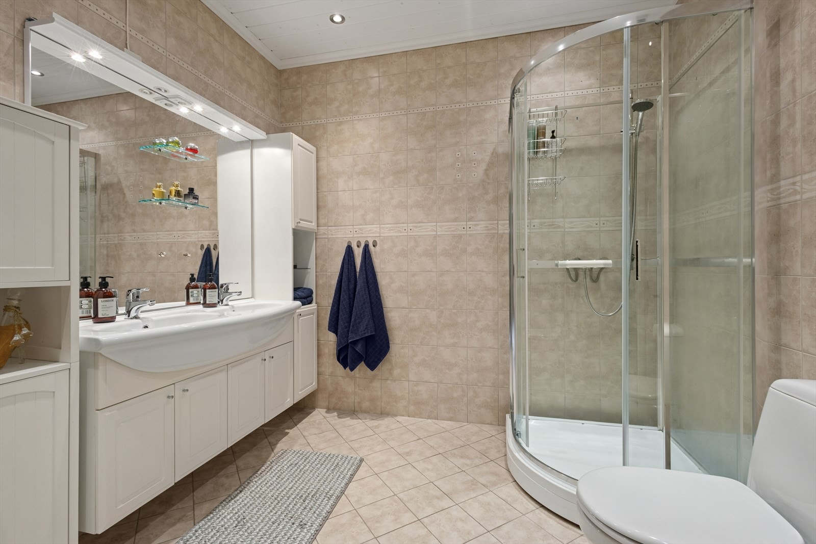 Badet er flislagt og har elektriske varmekabler i gulvet. Galleribilde