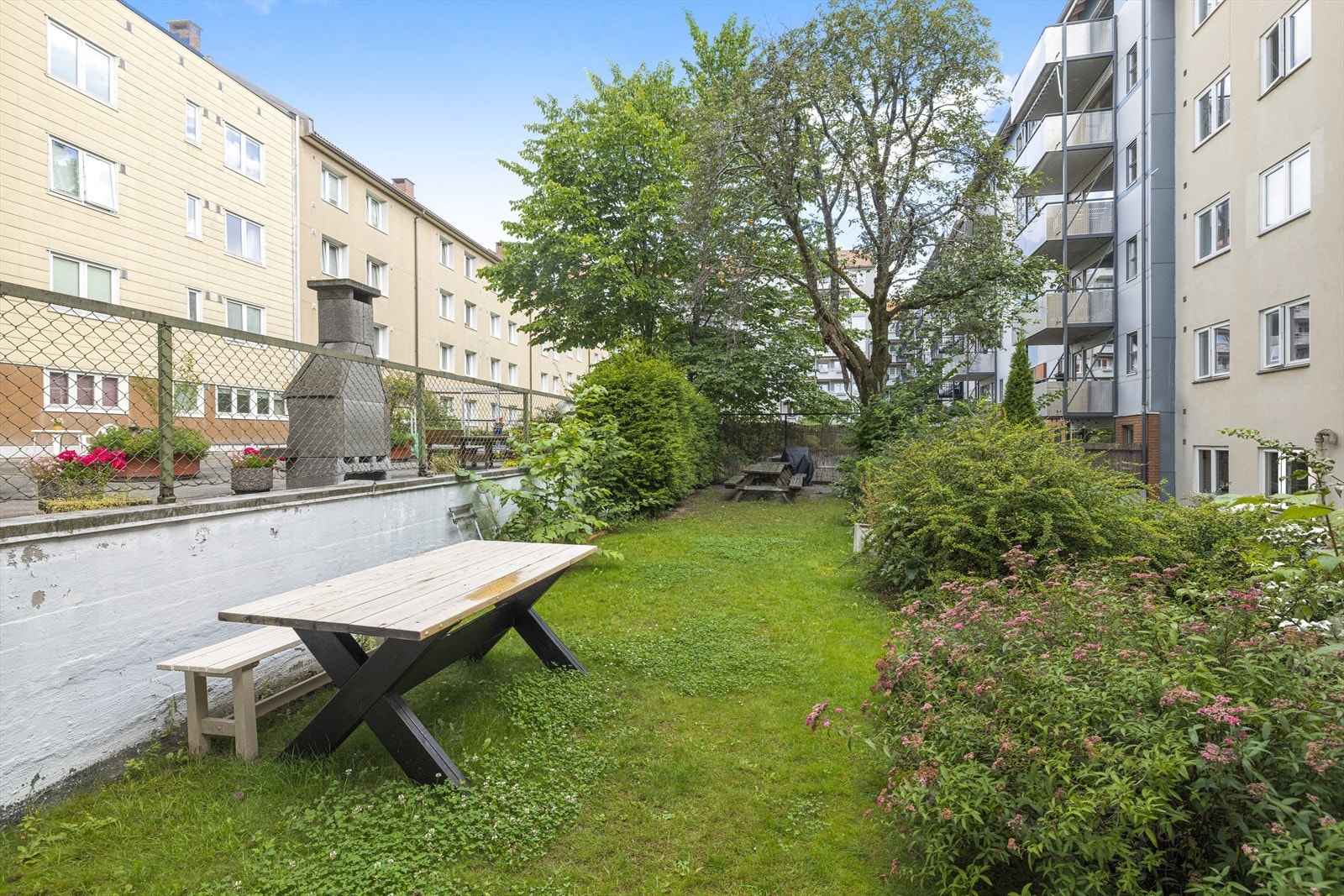Fellesarealene ute i bakgården er velholdte og innbydende, med grillmuligheter, langbord og hyggelige sitteplasser - perfekt til sosiale sammenkomster. Dette er en bolig hvor det er lett å trives! Galleribilde
