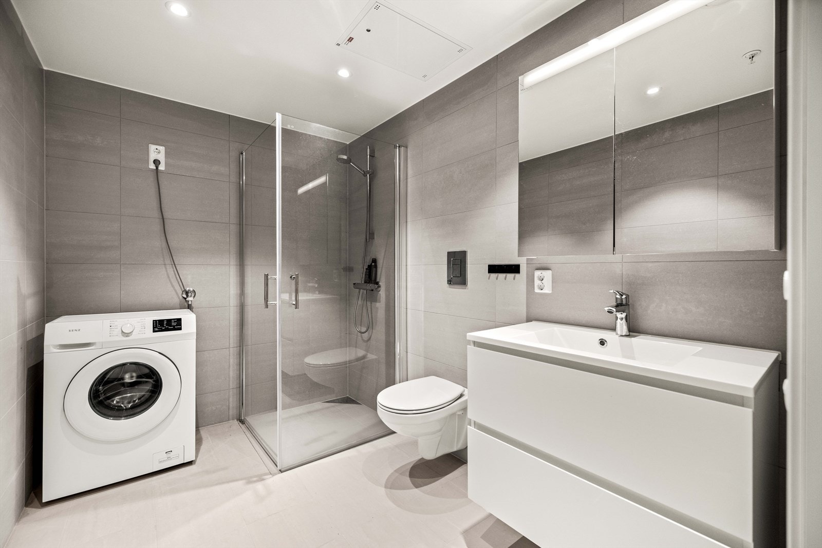 Komplett, flislagt baderom med opplegg for vaskemaskin. Galleribilde