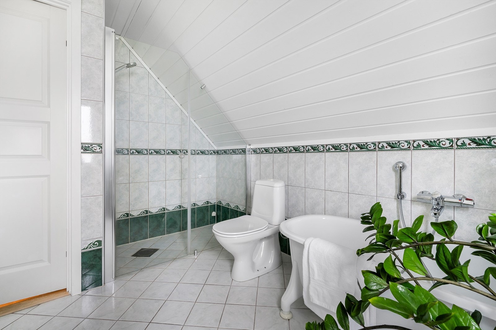 Hovedbadet er innredet med en bred baderomsinnredning, WC, dusjhjørne og badekar med dusjbatteri. Galleribilde