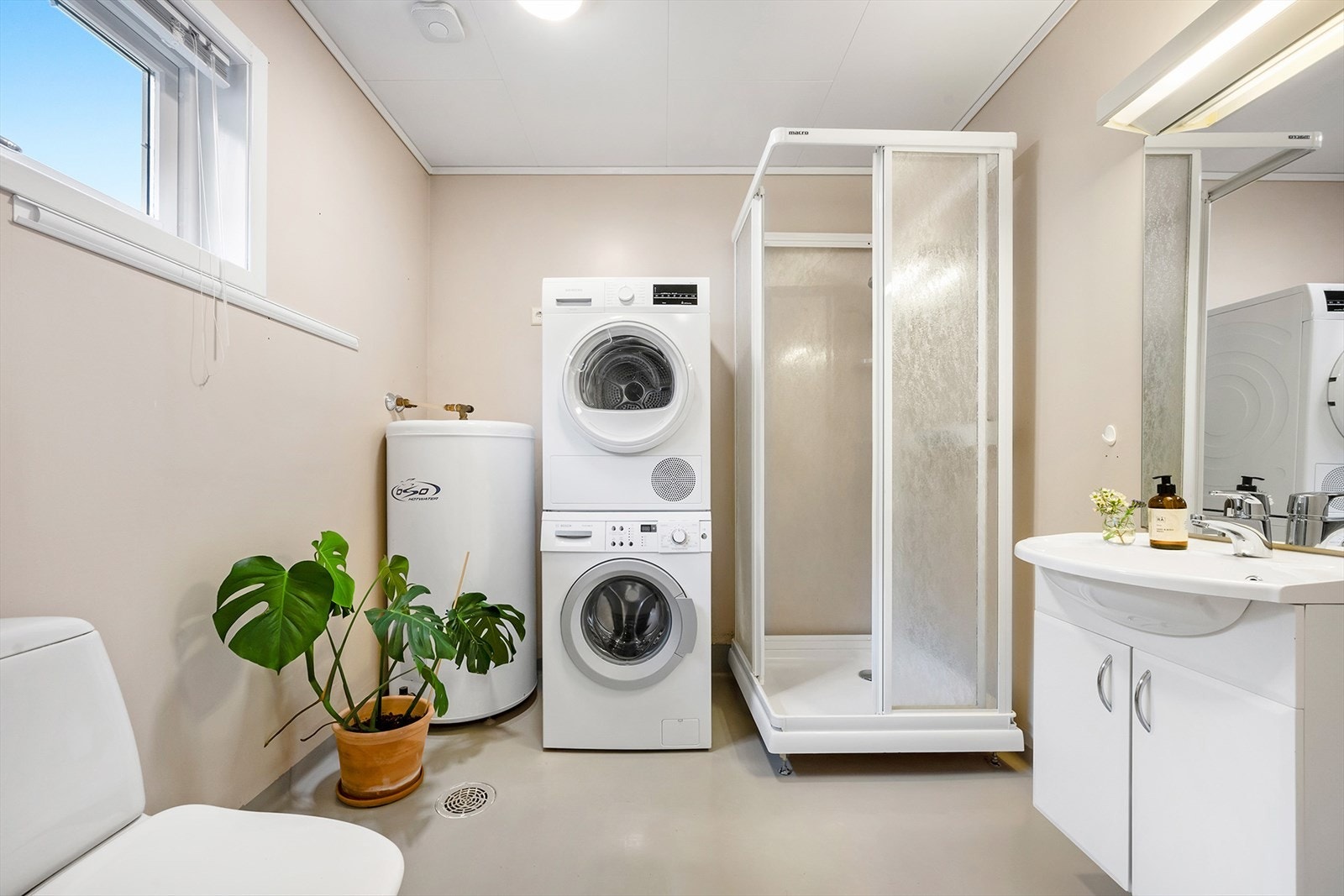 Badet i hovedetasjen er fullverdig med toalett, dusj og baderomsinnredning. Det er montert opplegg for vaskemaskin og tørketrommel på dette badet. Galleribilde