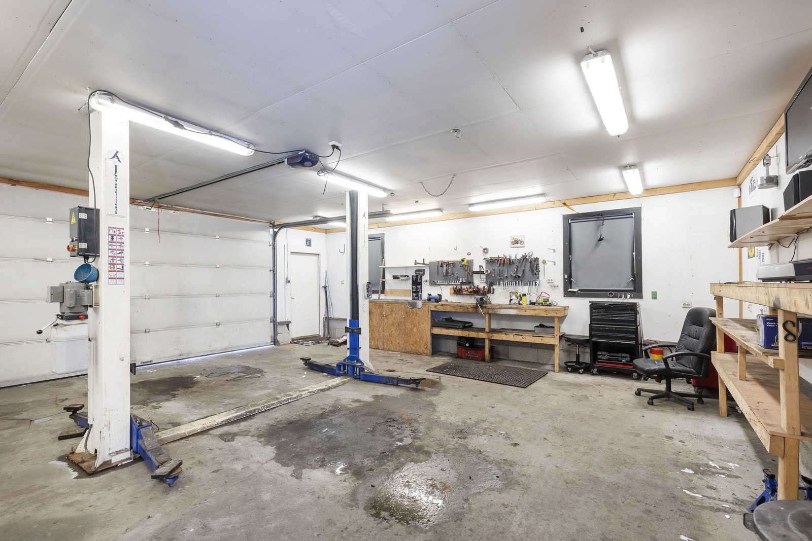 Denne store garasjen er innredet med løftebukk, bod og kontor Galleribilde