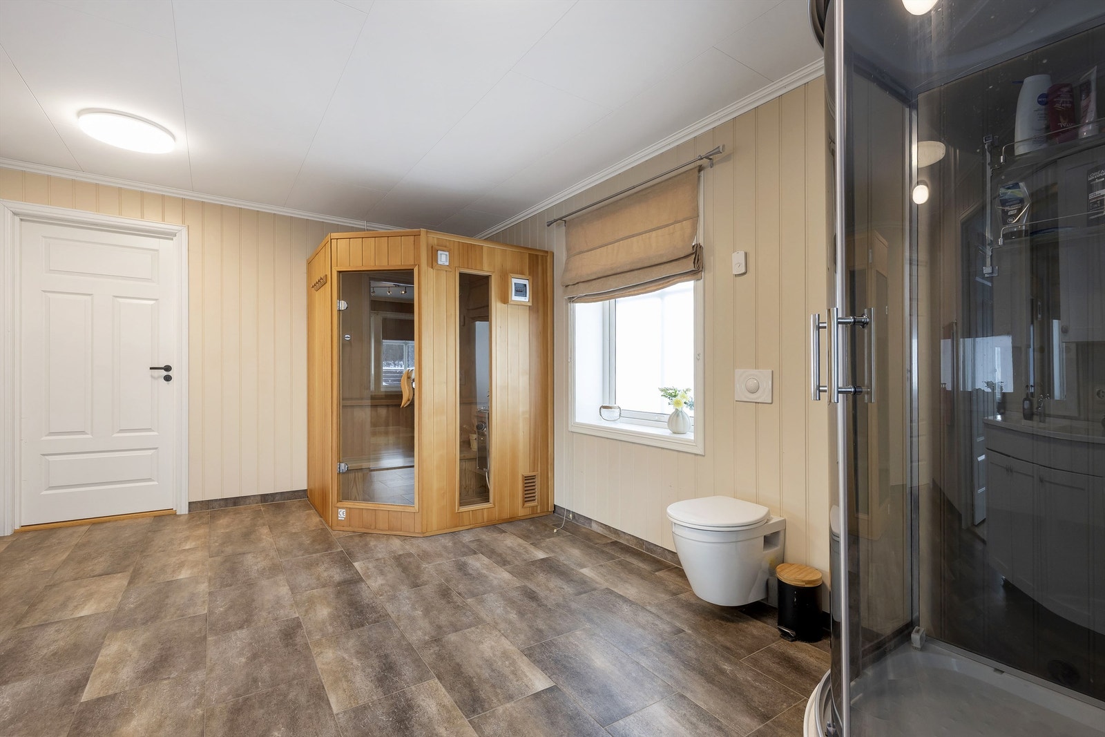 Særdeles romslig bad/vaskerom med dusjkabinett (nytt), wc, badstue og innredning med servant og utslagsvask Galleribilde