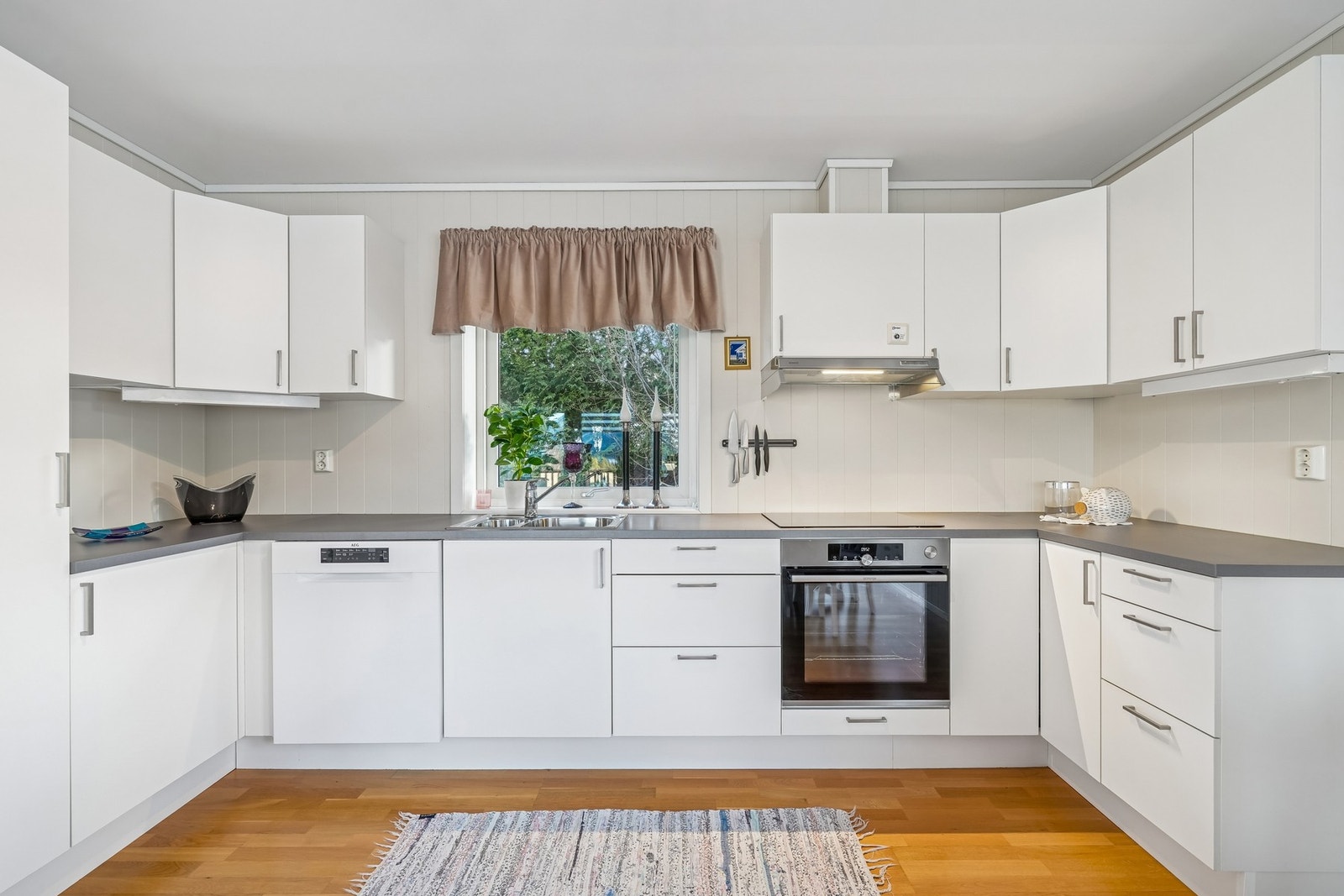 Pent kjøkken med integrerte hvitevarer. Både platetopp og oppvaskmaskin er byttet og er nyere Galleribilde