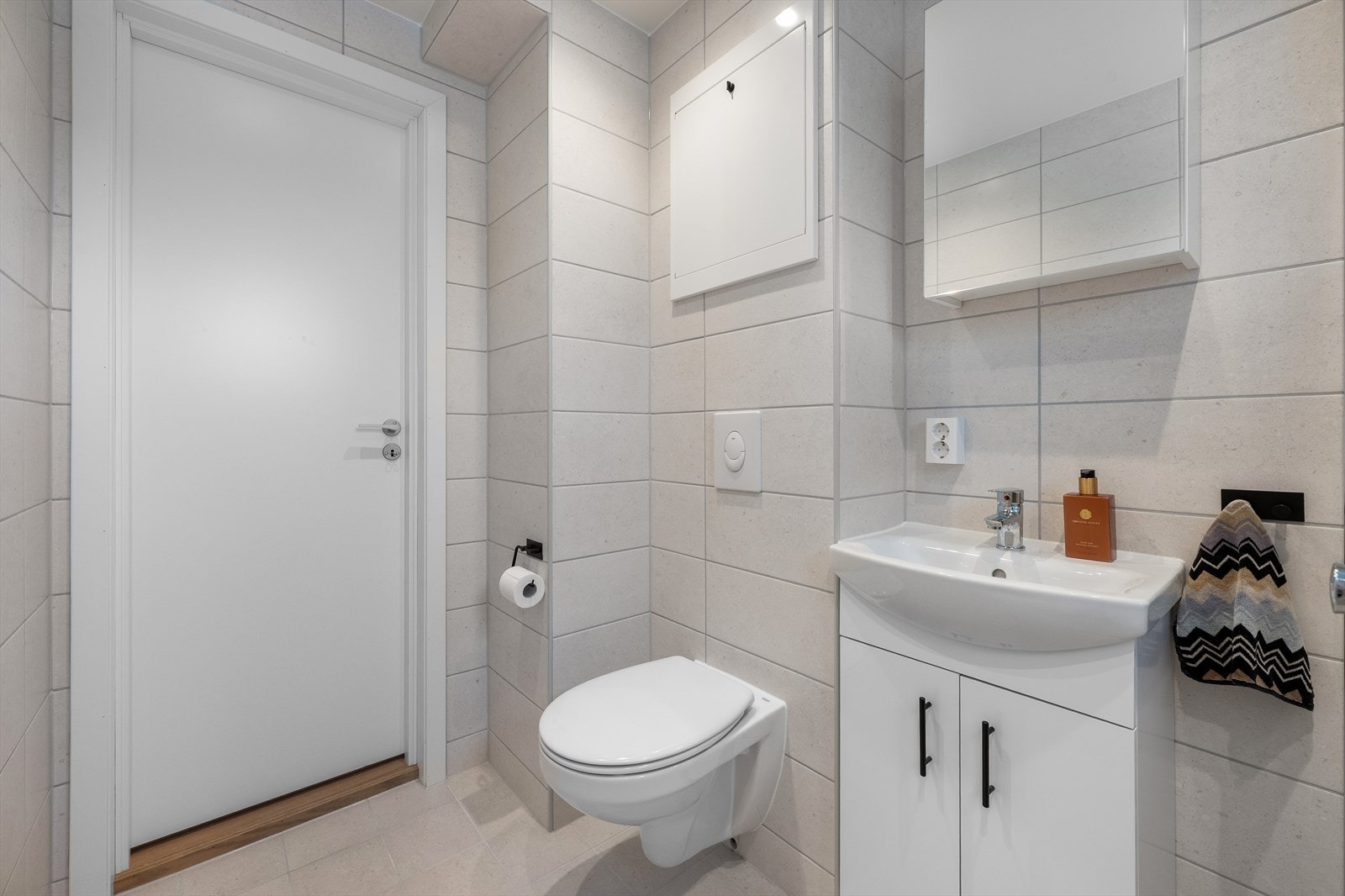 Badet er utstyrt med veggmontert toalett, servantinnredning og speilskap. Galleribilde