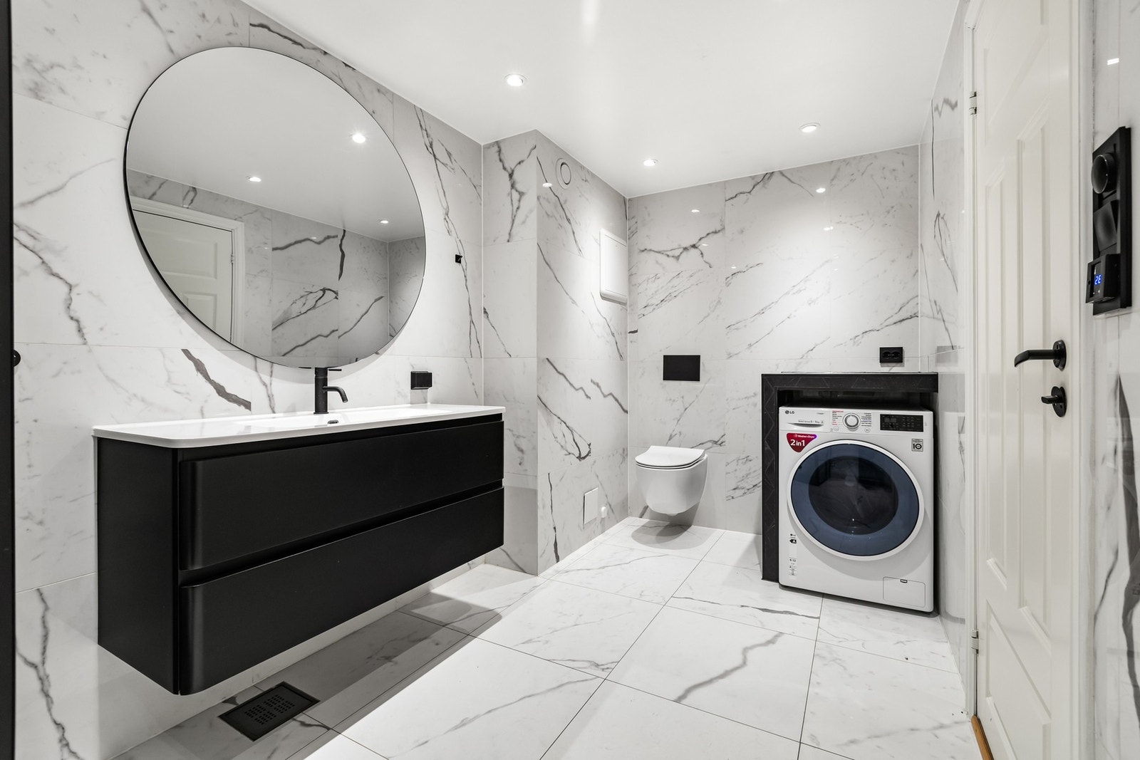 Delikat og flislagt bad med gulvvarme, dusjhjørne og vegghengt toalett. Praktiske løsninger og moderne uttrykk gir god komfort i hverdagen. Galleribilde