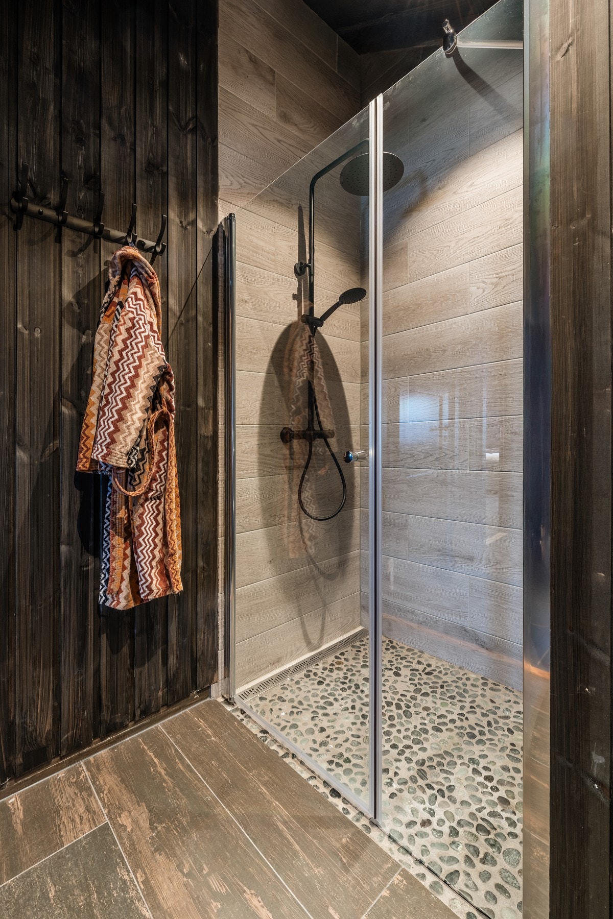 Dusjsonen har lekker flis på vegg og elvestein på gulv Galleribilde