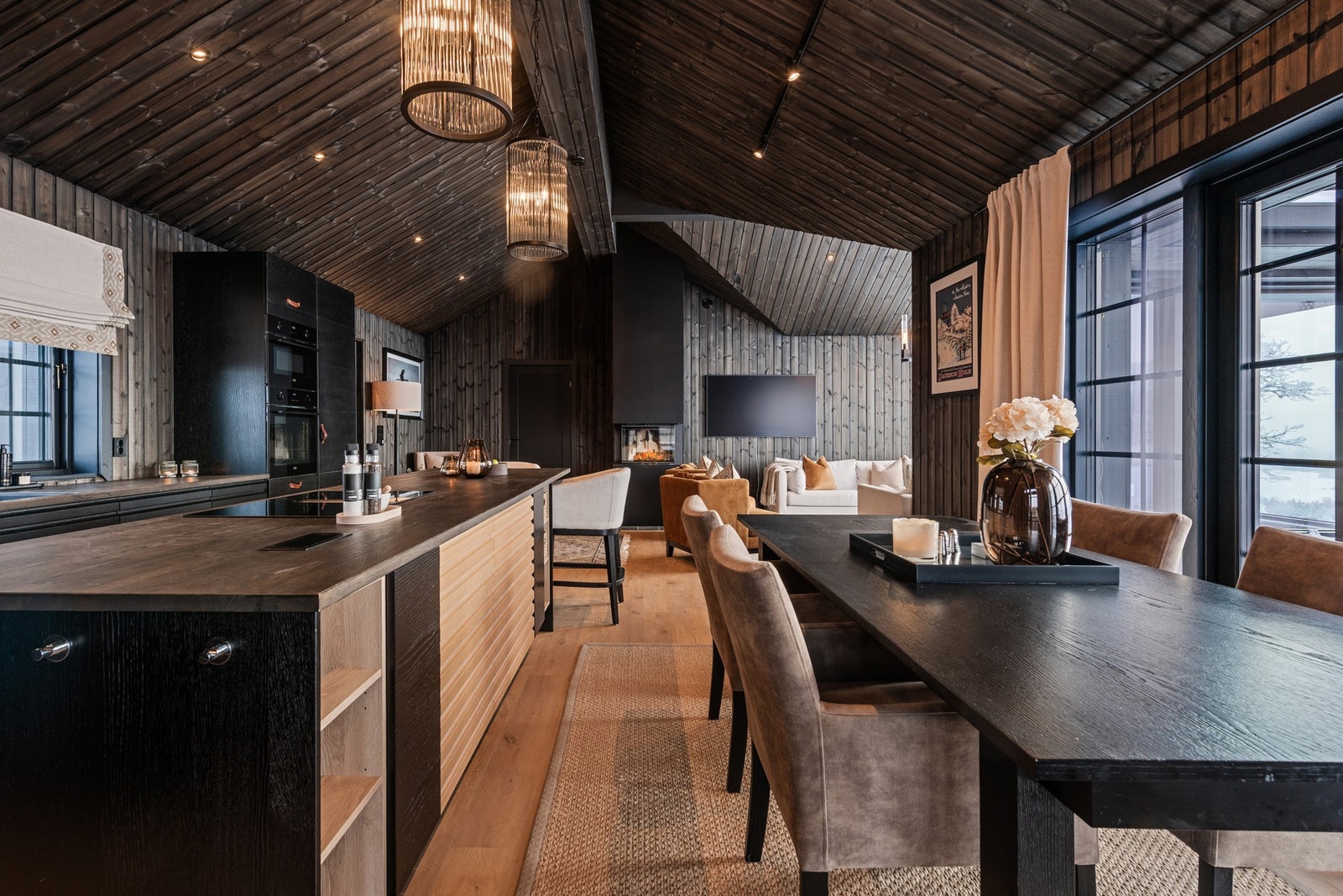 Åpne stue- og oppholdssone med imponerende takhøyde, store vinduer og en varm, gjennomført hyttestil Galleribilde
