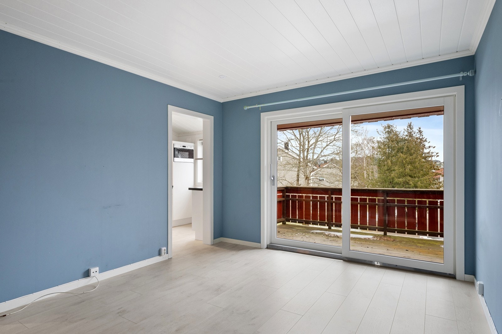 Stuen er malt i en tidsriktig blåtone på de slette veggene. På gulvet er det moderne enstavs-laminat og i himlingen er det malt panel. Galleribilde