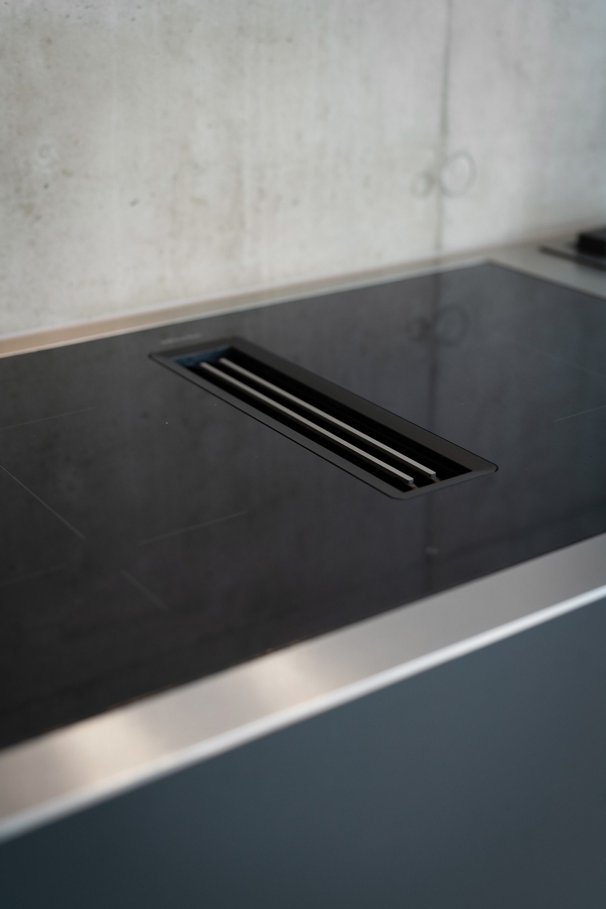 Benkeplaten er i metall med nedfelt kum og integrert komfyr/ koketopp fra Miele med nedfelt kullfiltervifte Galleribilde