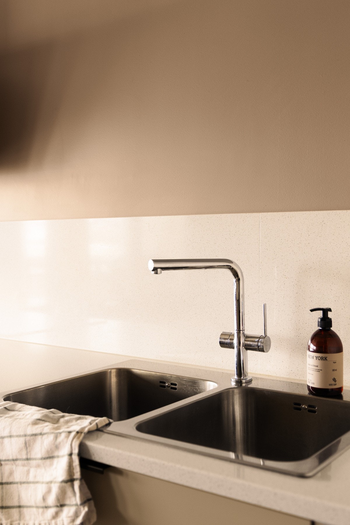 Nedsenket oppvaskkum med ettgreps armatur og komposittplater på veggene over benkeplaten gir både et helhetlig preg og en praktisk arbeidsflate. Galleribilde