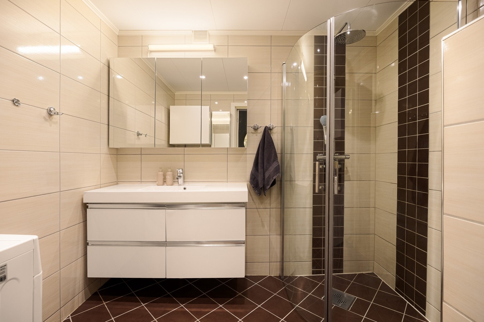 Baderommet fra 2013 har flislagte overflater med gulvvarme og er innredet med vegghengt servantskap, nedsenket servant og speilskap med belysning. Galleribilde