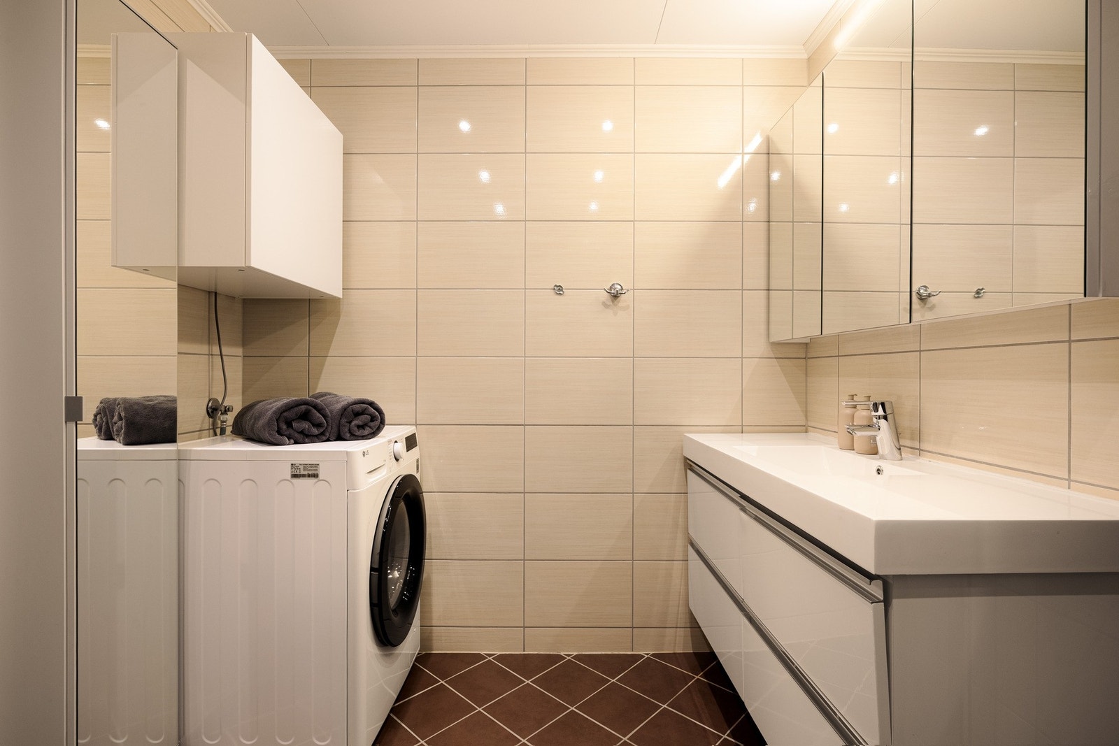 Dusjhjørnet har innfellbare glassdører og er utstyrt med både hånddusj og regndusj, og baderommet har i tillegg opplegg for vaskemaskin. Galleribilde