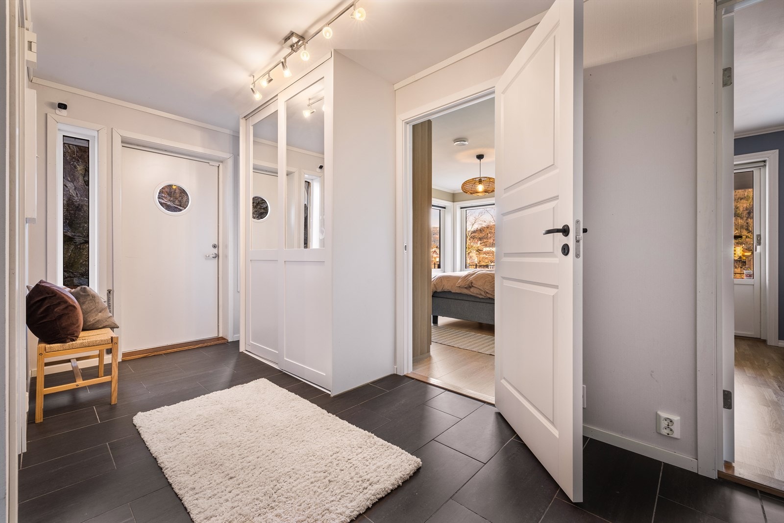 Lys og romslig entré, med fliser på gulv. Her har man varme i gulv og en stor speilgarderobe med plass til både sko og yttertøy. Galleribilde