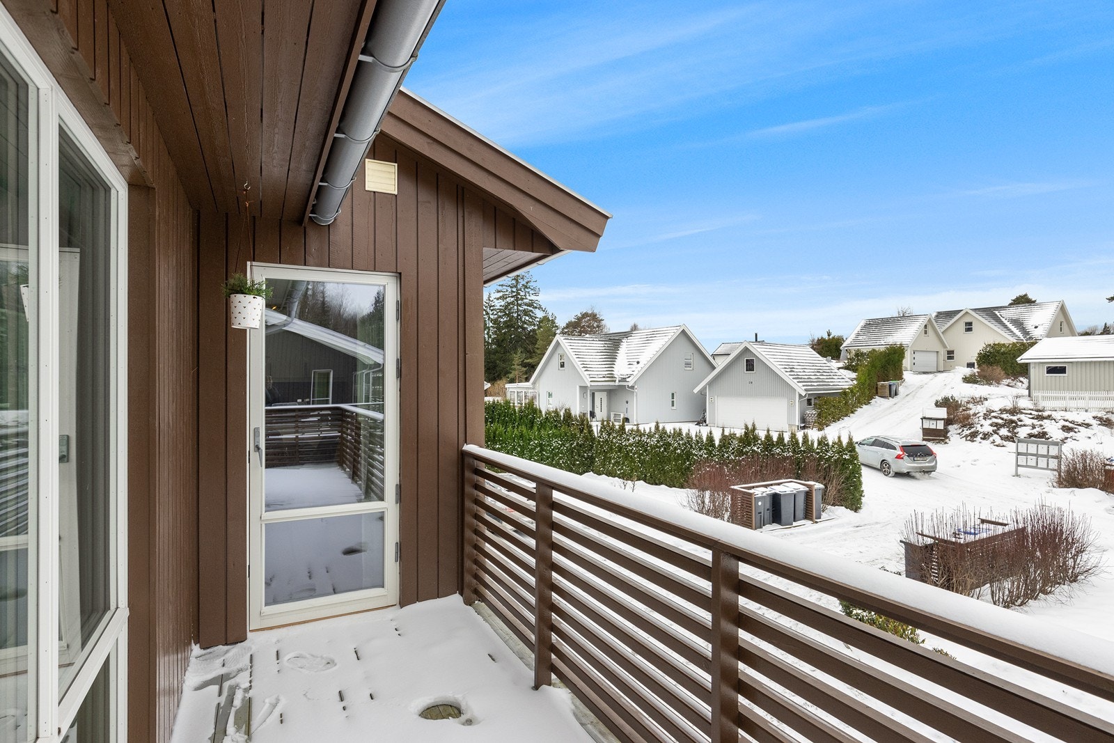 Balkongen har rekkverk i tre og gir utsyn over nabolaget. Galleribilde