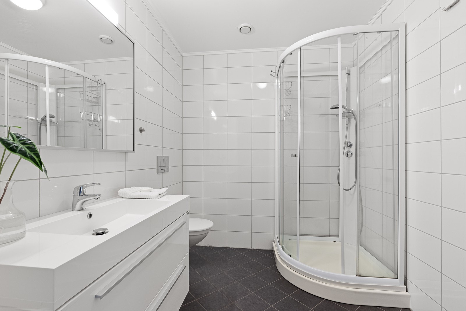 Badet i første etasje er helfliset, har varmekabler og er innredet med dusjkabinett. Galleribilde