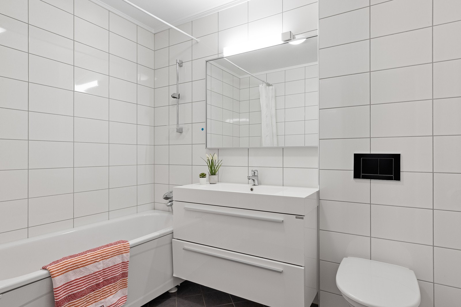 Badet i underetasjen er helfliset og utstyrt med badekar og varmekabler i gulvet. Galleribilde