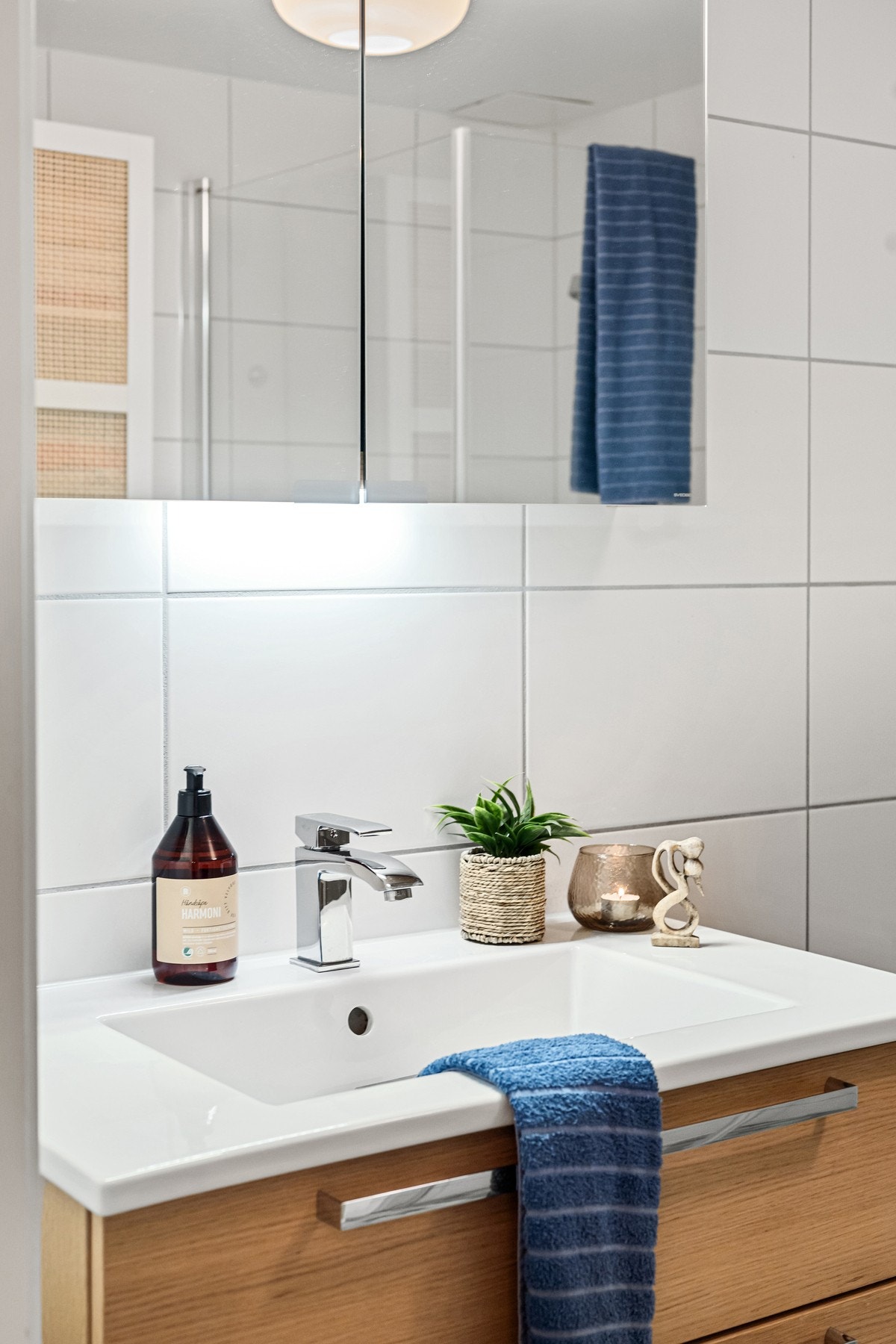 Badet har dusjhjørne, vegghengt toalett, servant og speil. Galleribilde