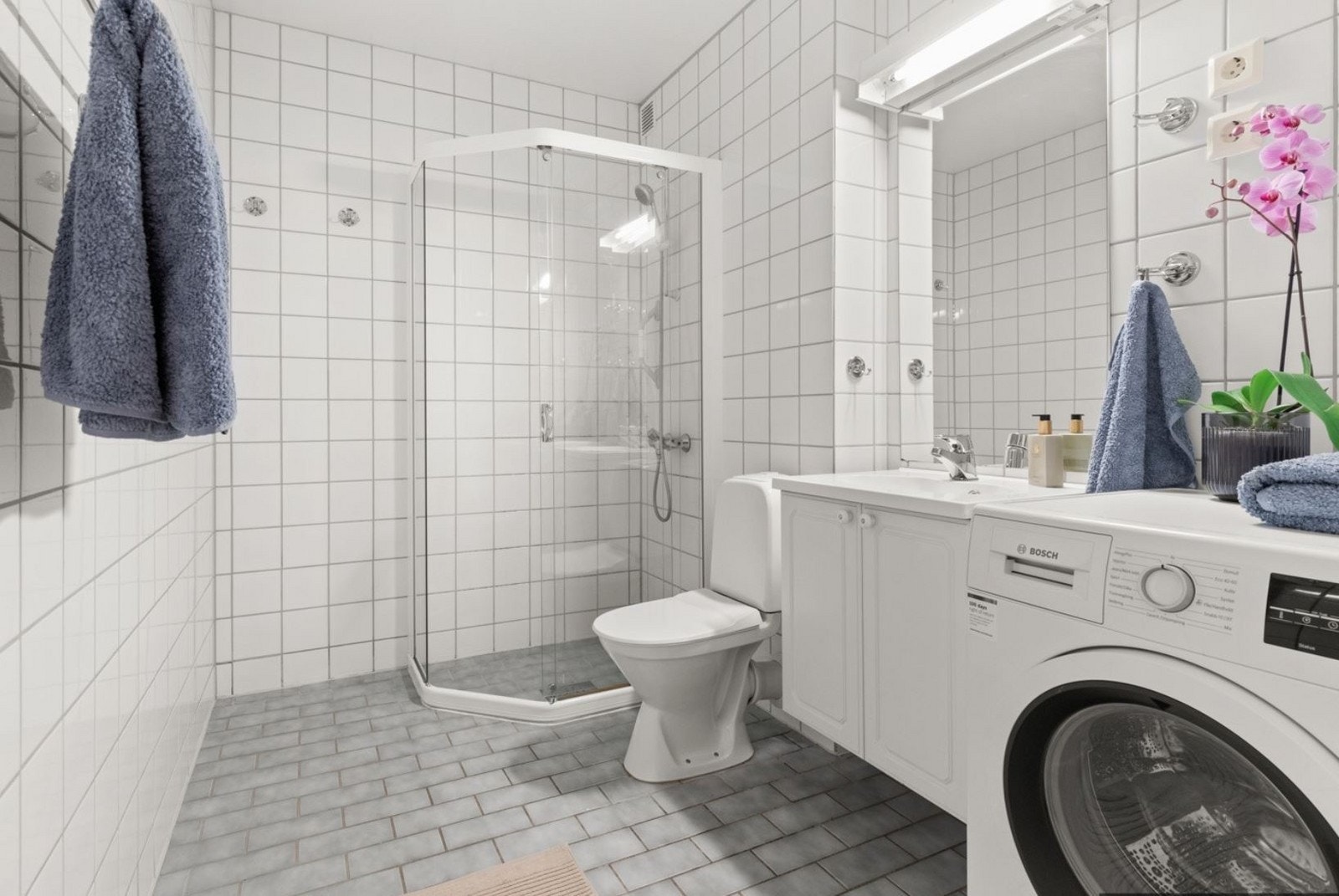 Flislagt bad med dusj, vask, wc og vaskemaskin Galleribilde