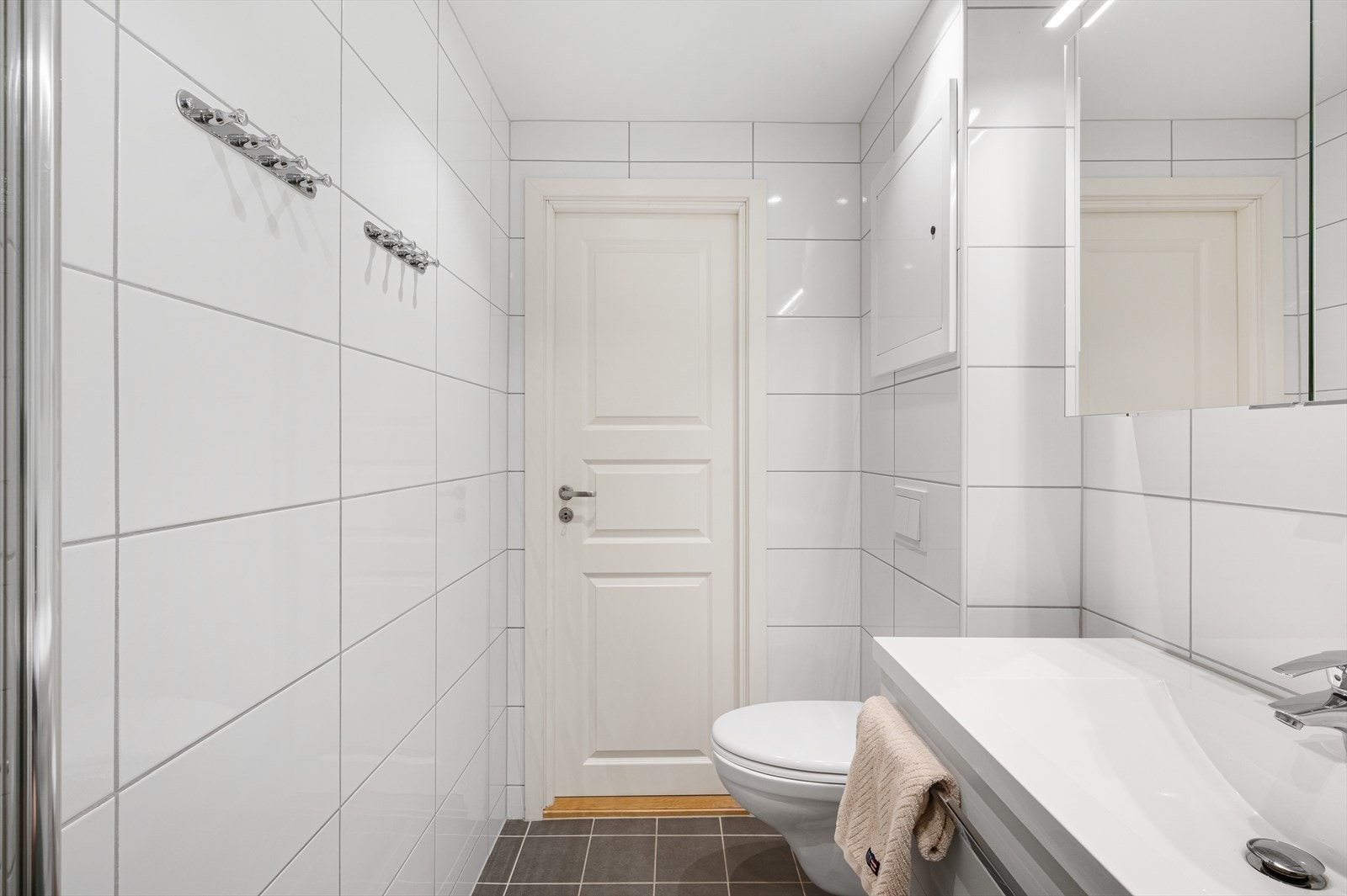 - Badet er innredet med heldekkende servant, vegghengt toalett, dusjhjørne, speilskap med belysning og opplegg for vaskemaskin - Galleribilde