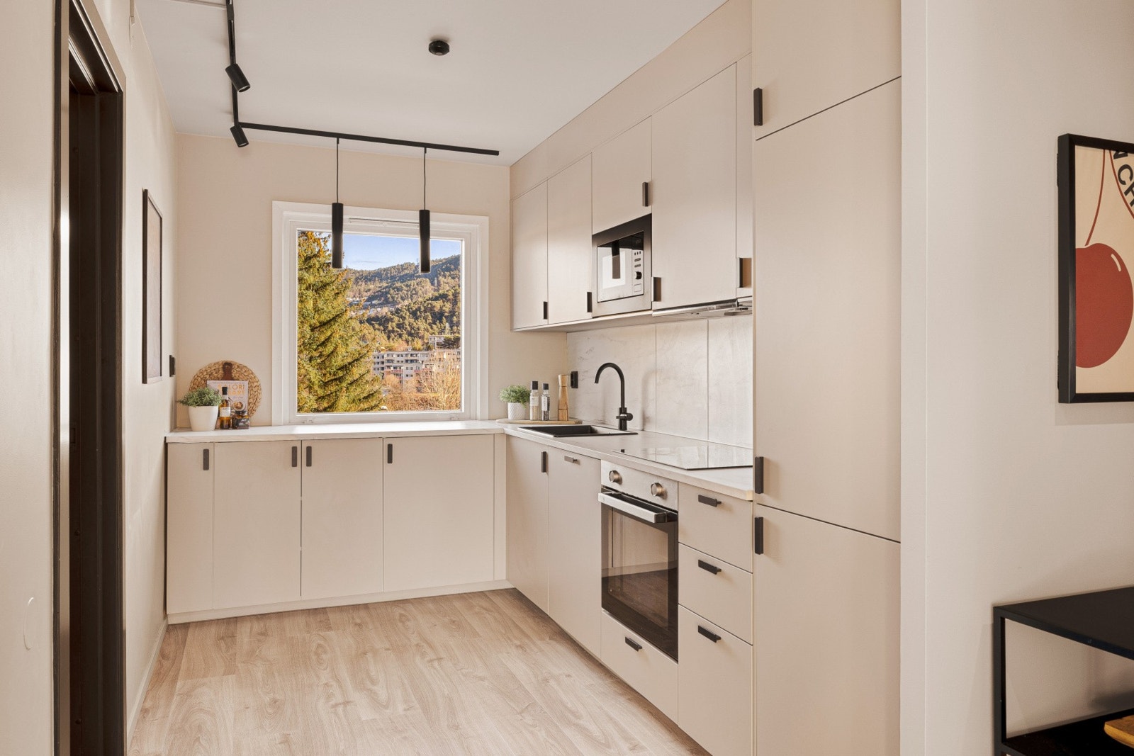 Kjøkkenet ble pusset opp i 2023 med slette beige fronter og benkeplate i laminat. Galleribilde