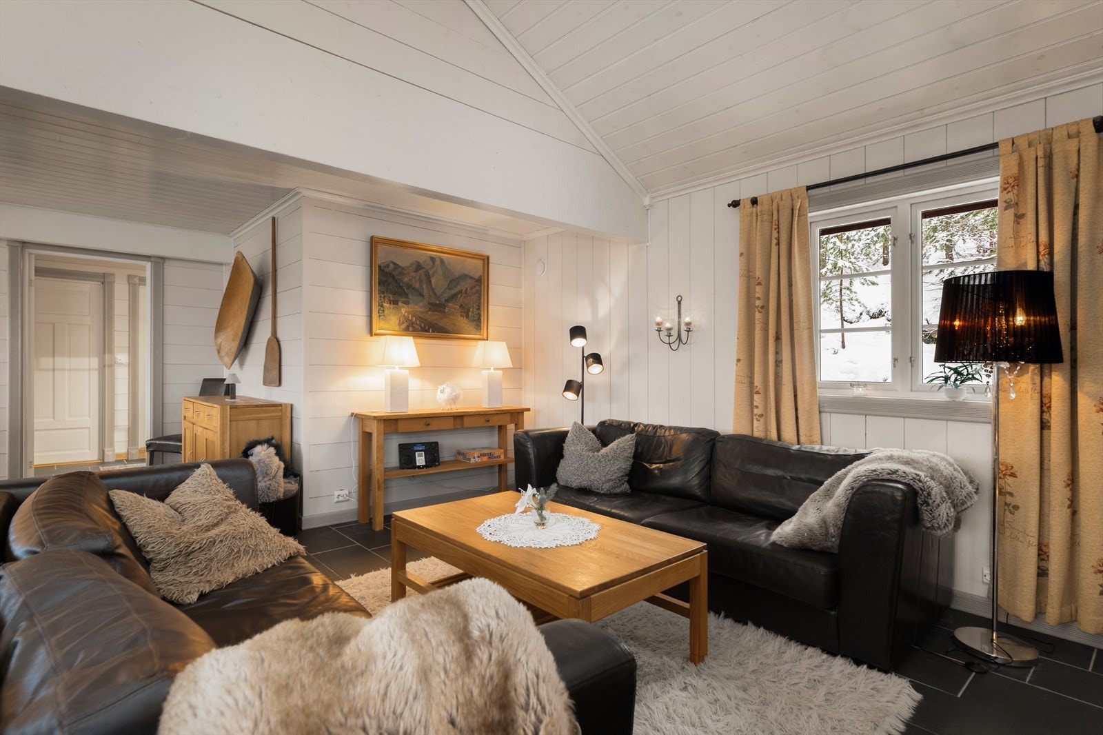 Overflater består av laminat og fliser på gulv, trepanel på vegger og trepanel i tak. Det er varmekabel i gulv på bad, vaskerom, stue og entre. Galleribilde