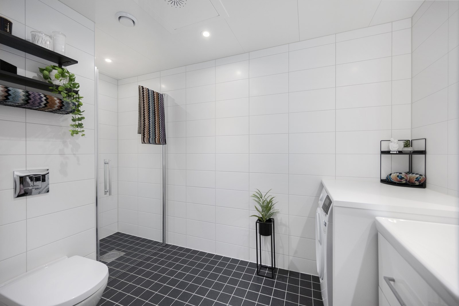 Romslig og lyst bad med flislagte overflater, gulvvarme og downlightsbelysning. Galleribilde