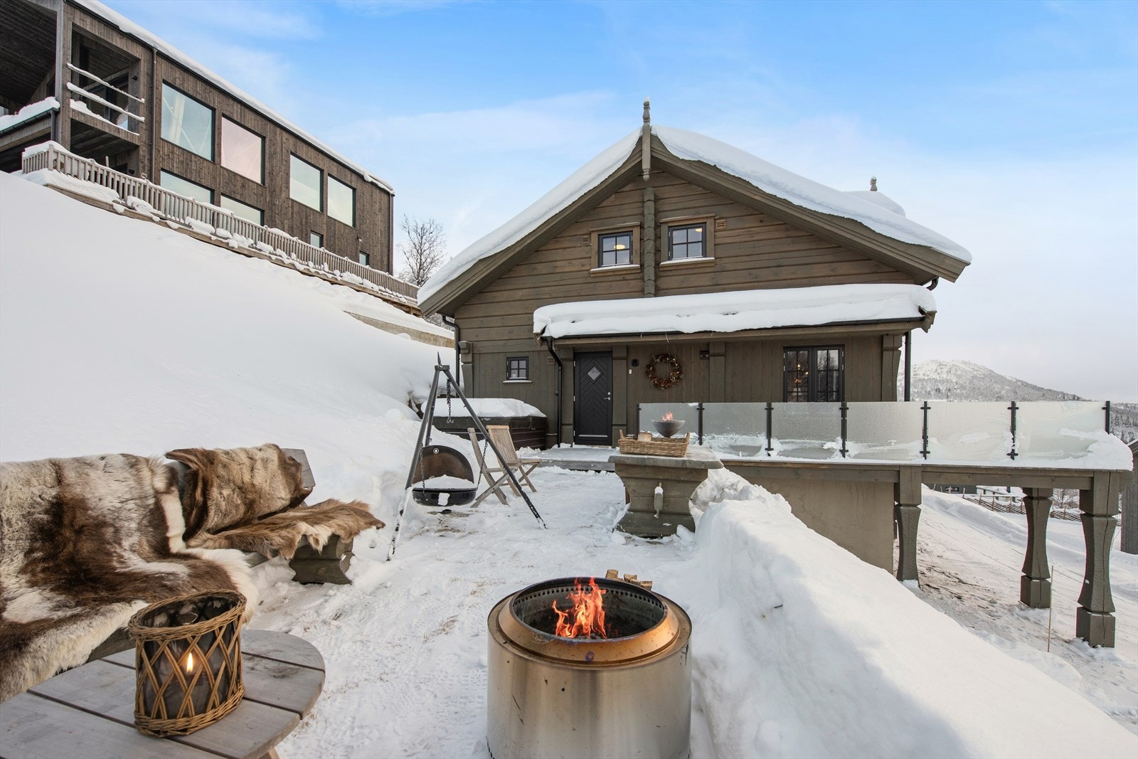 Uteområdet er intet mindre enn magisk. En stor terrasse ligger rett utenfor døren og blir et naturlig samlingspunkt året rundt. Her er det jacuzzi, en stemningsfull bålplass og rikelig med plass til å nyte lange kvelder under stjernehimmelen. Galleribilde