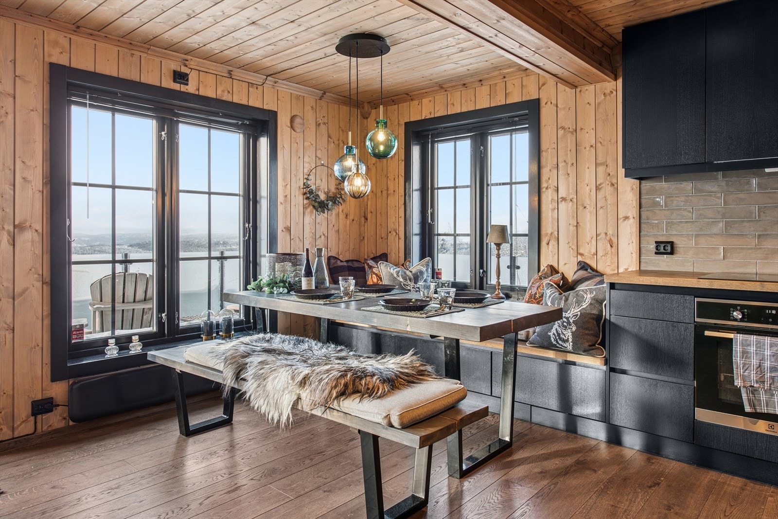 Store vinduer slipper inn naturlig lys og gir utsikt fra spiseplassen. Galleribilde